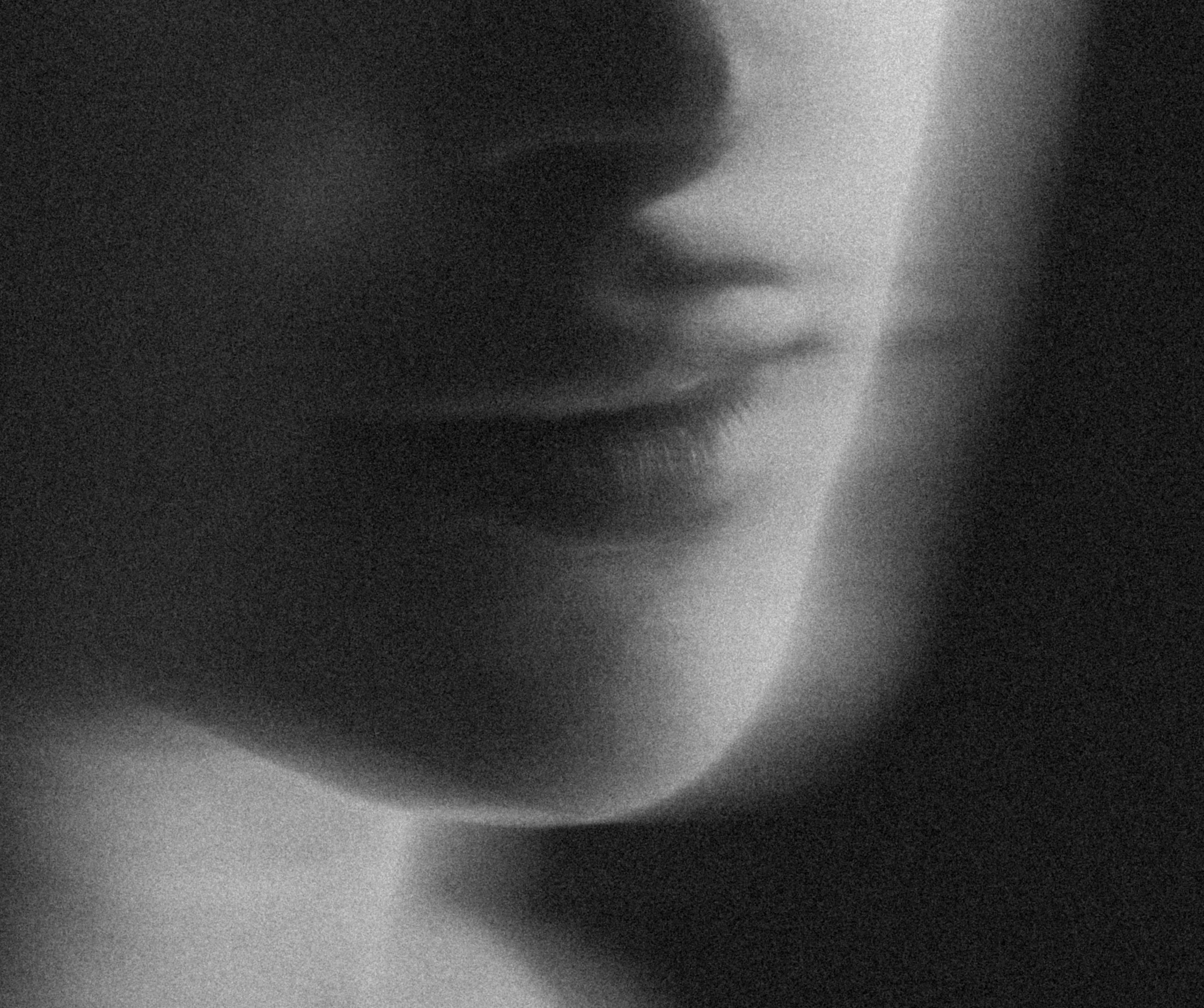 Close-up of a nose in black and white, showing textures and shadows.