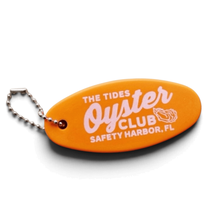 Orange keychain shaped like a surfboard with the text 'The Tides Oyster Club, Safety Harbor, FL' and a oyster shell graphic.