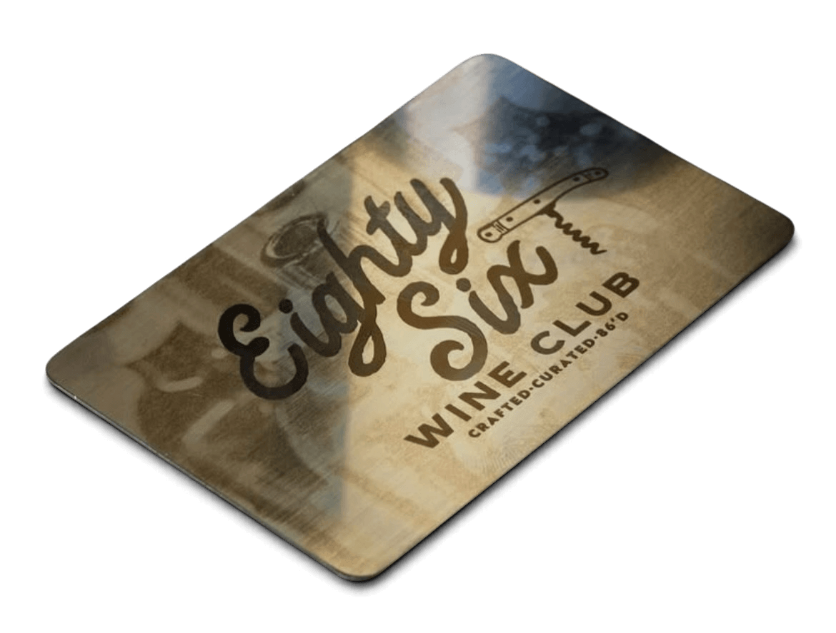 A rectangular card with the text 'Eighby Six Wine Club' and a corkscrew graphic on it, featuring a background of a wine glass and a blurred outdoor scene.