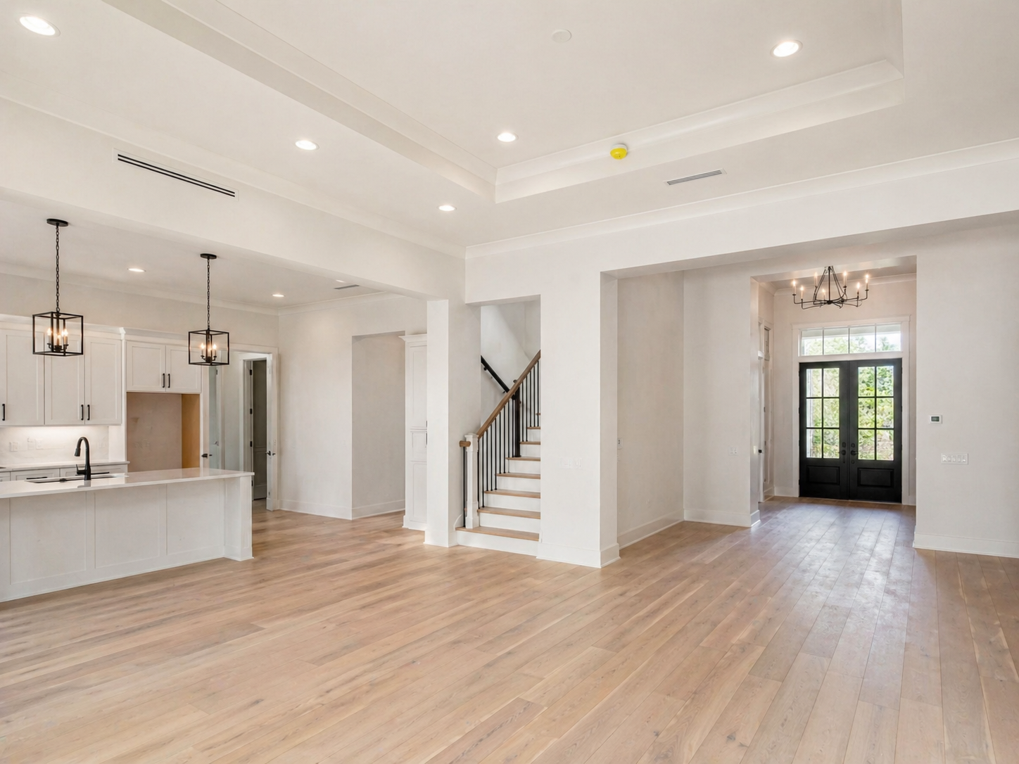 New construction painting in a newly built residential interior with clean white walls, finished trim, and completed surface preparation throughout the open living space.