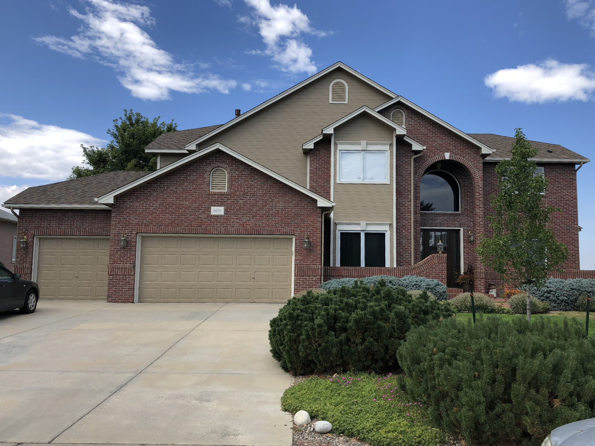 Residential exterior repainting project featuring updated siding colors, brick accents, detailed trim work, and refreshed curb appeal for a large custom home. Professional exterior painting and siding painting services for residential repaint project