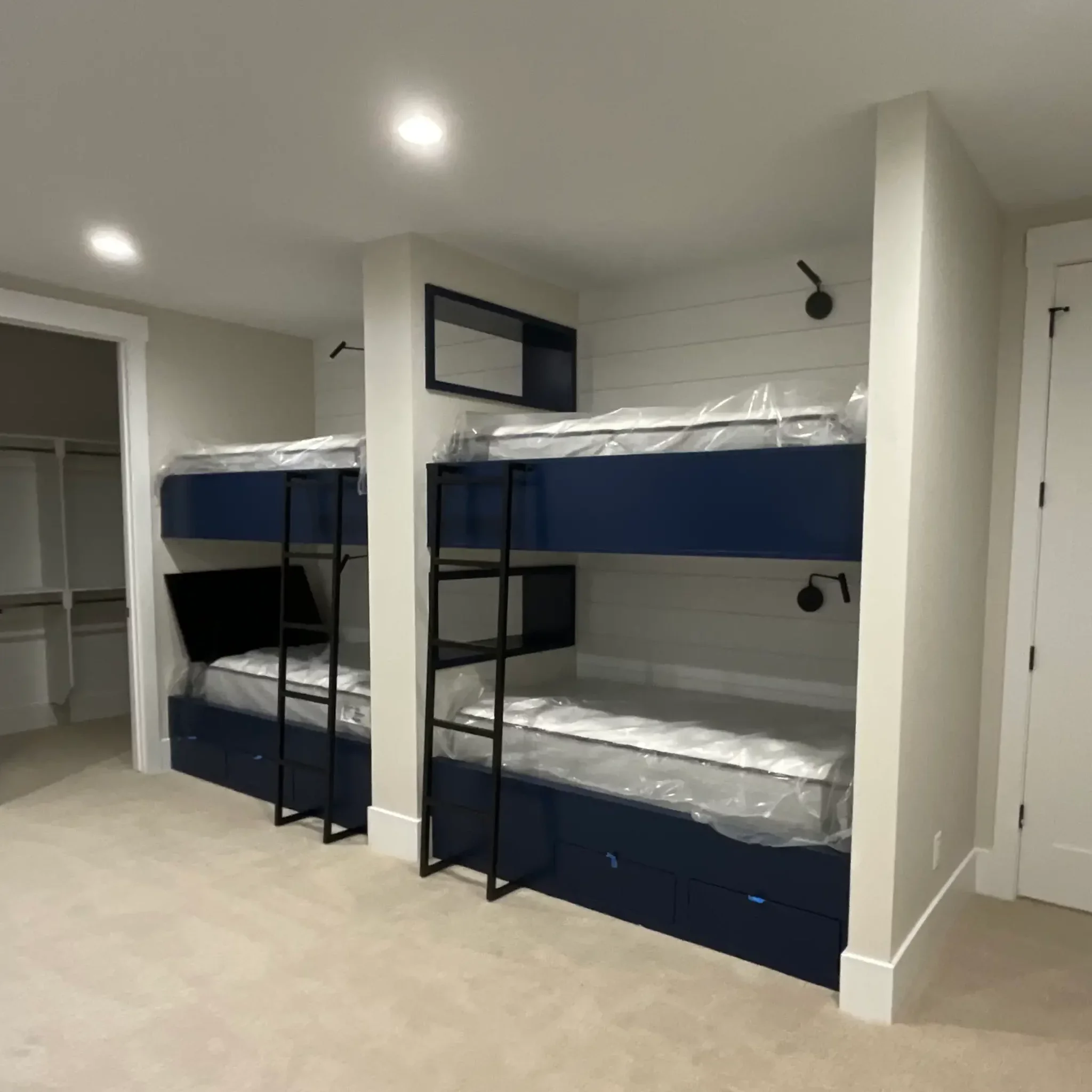 Custom bunk room interior painting project featuring built-in bunk beds, modern accent lighting, shiplap wall detailing, and clean contemporary finishes for a luxury residential retreat. Professional interior painting and fine finish services for chi