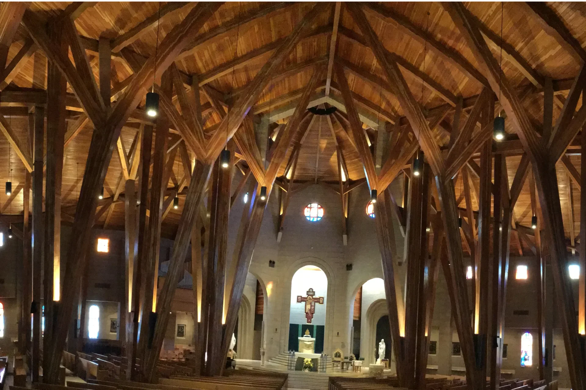 Large-scale commercial and institutional interior featuring custom heavy timber architecture, exposed structural wood beams, vaulted ceilings, specialty wood finishes, and high-end architectural coating work. Professional commercial painting, stainin