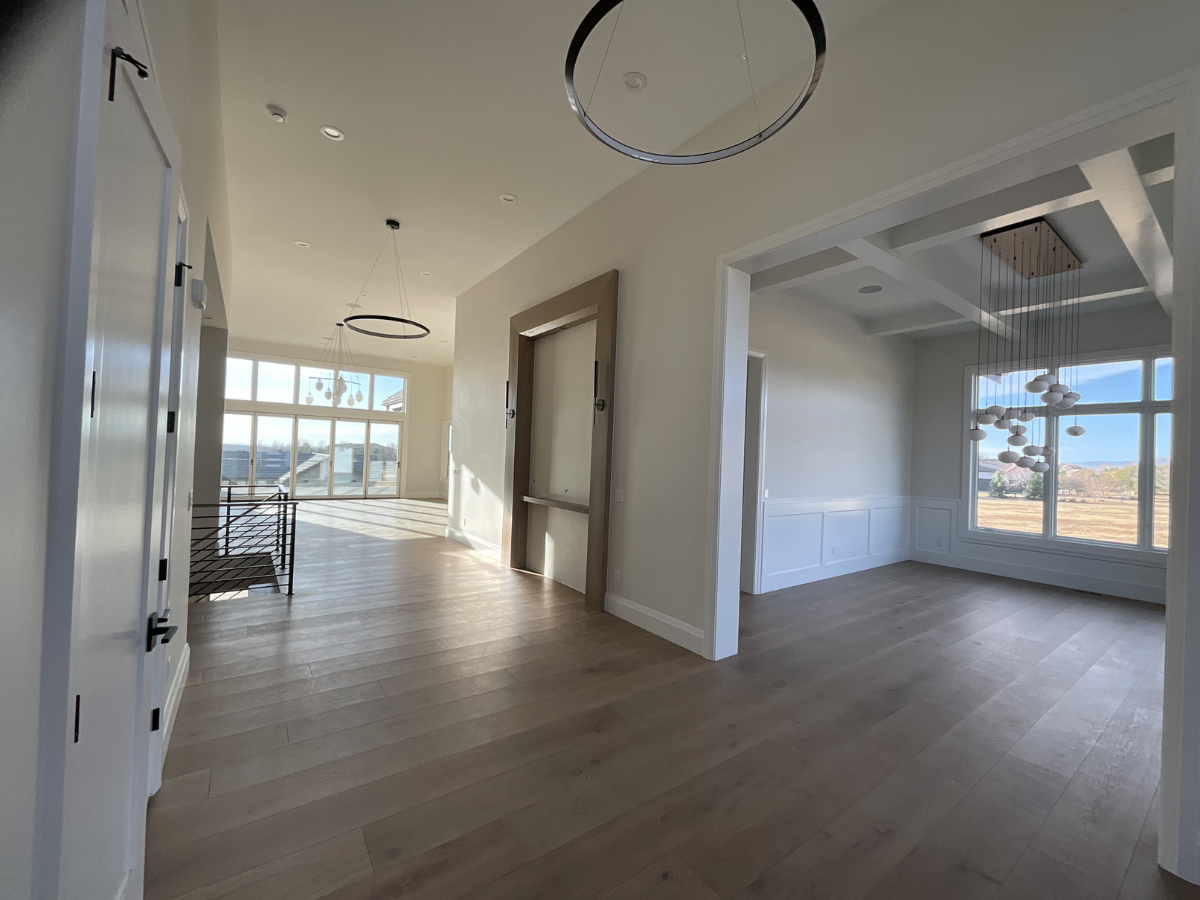 High-end residential interior painting project featuring bright open-concept living spaces, modern trim work, coffered ceilings, oversized windows, and contemporary luxury finishes. Professional interior painting and custom home finishing services fo