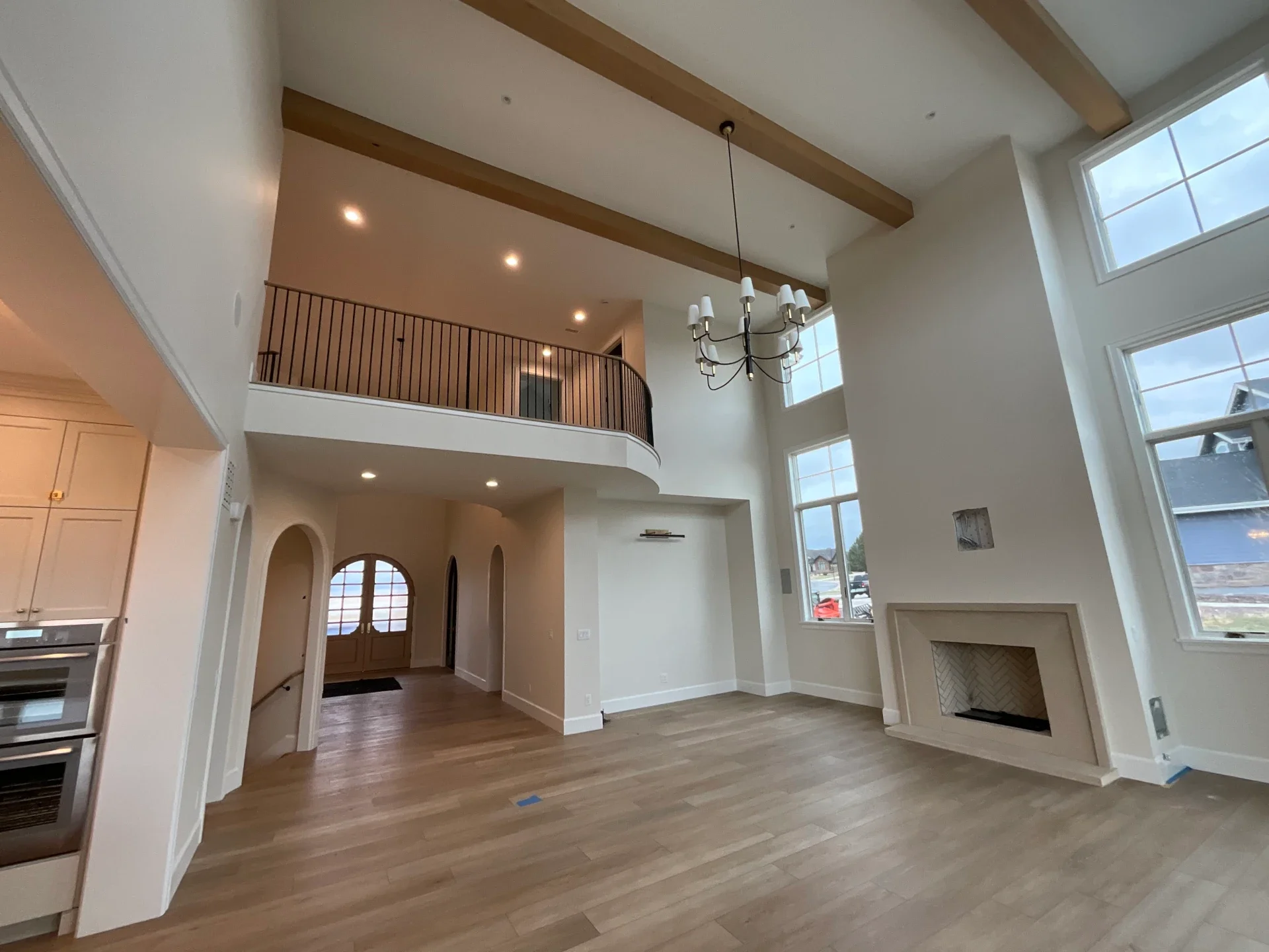 Interior house painting services in Denver featuring a bright open-concept great room with vaulted ceilings, exposed wood beams, tall windows, and detailed finish work in a custom residential interior.