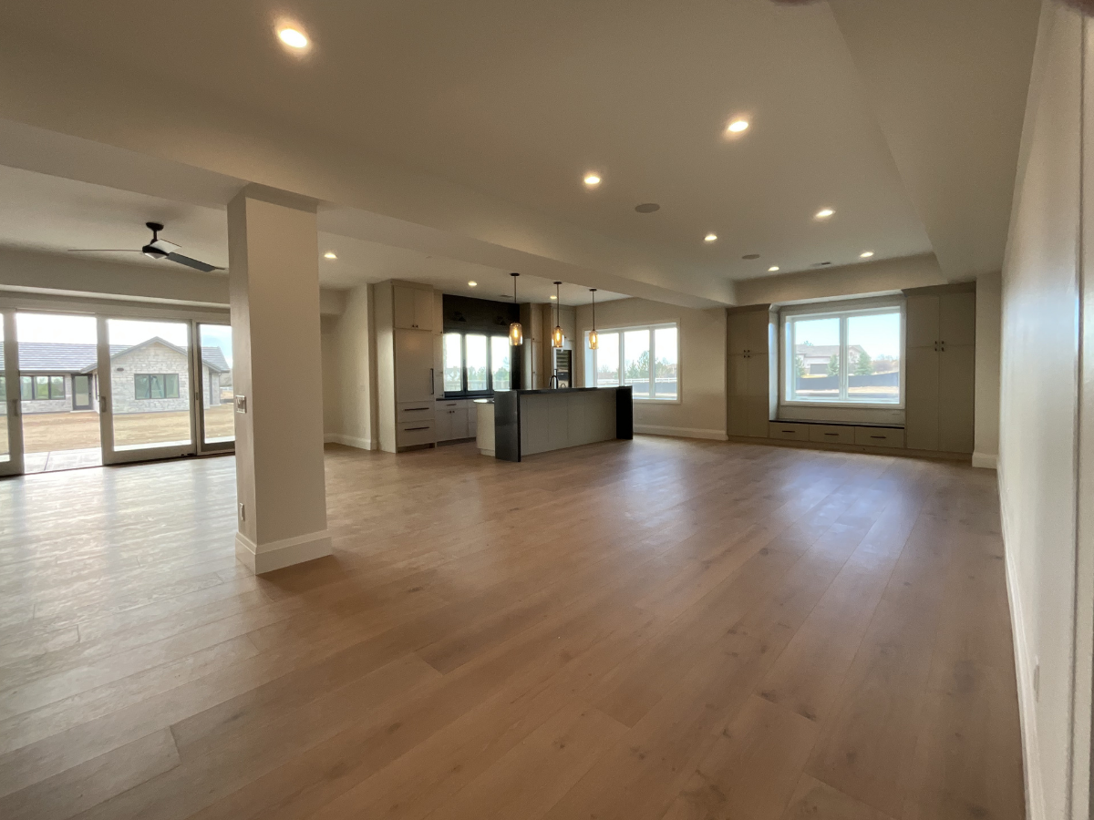 Open-concept luxury home interior with neutral paint colors, recessed lighting, custom built-ins, and professionally finished walls and ceilings in modern Colorado residence.