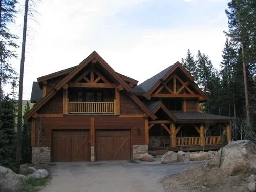 Exterior wood staining and painting project on a luxury custom mountain home featuring exposed timber beams, natural wood siding, rustic architectural detailing, and difficult-access exterior finishes. Professional painting and staining services for 