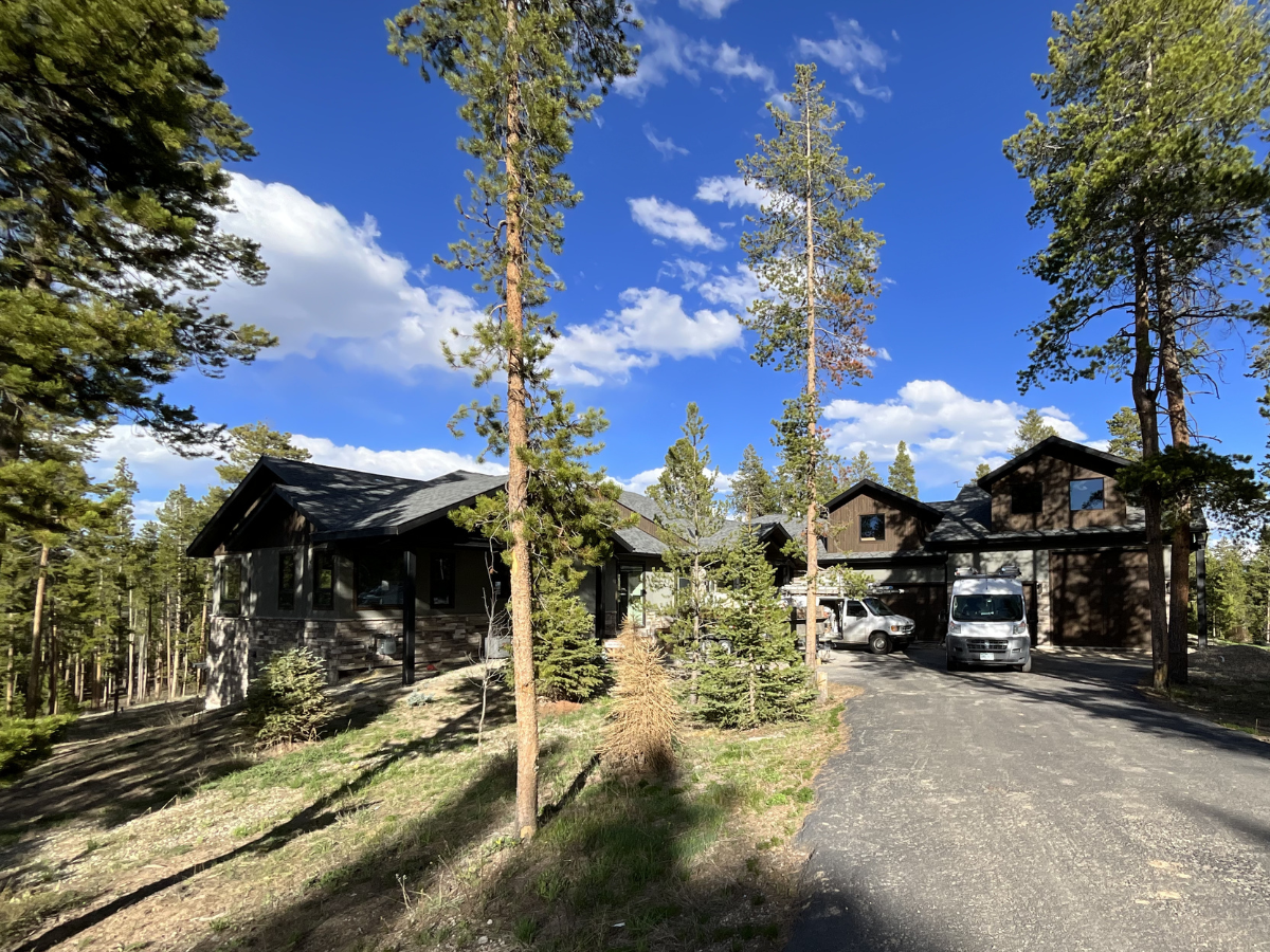 Rustic luxury home interior featuring exposed timber beams, natural wood finishes, stone accents, and professionally painted interior walls in custom Colorado mountain home.