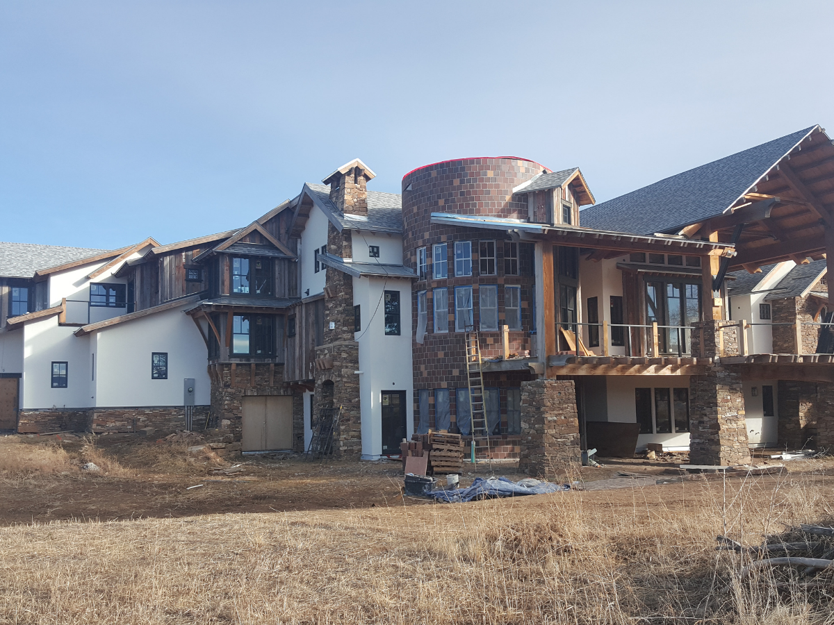 Large-scale custom commercial and luxury residential construction project featuring modern mountain architecture, heavy timber framing, natural stone masonry, exposed wood accents, and multi-material exterior finishes. Professional commercial paintin