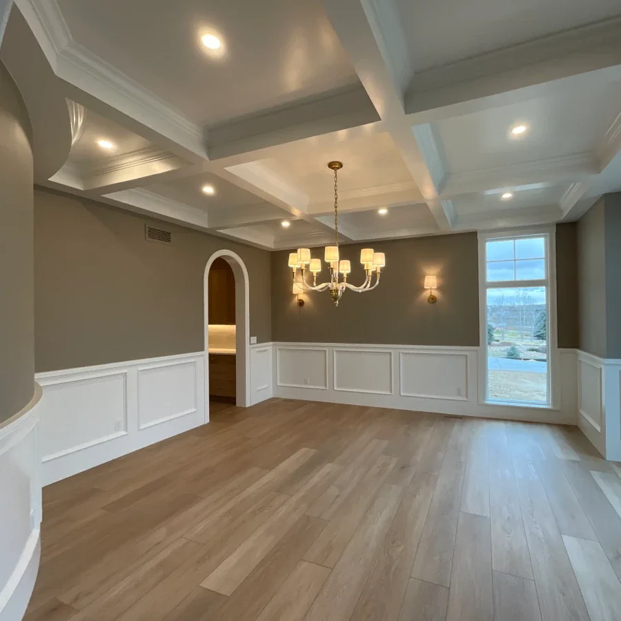 Elegant dining room interior painting project featuring detailed coffered ceilings, custom wall molding, neutral designer color palettes, and luxury architectural finishes. Professional interior painting and fine finish services for formal dining roo