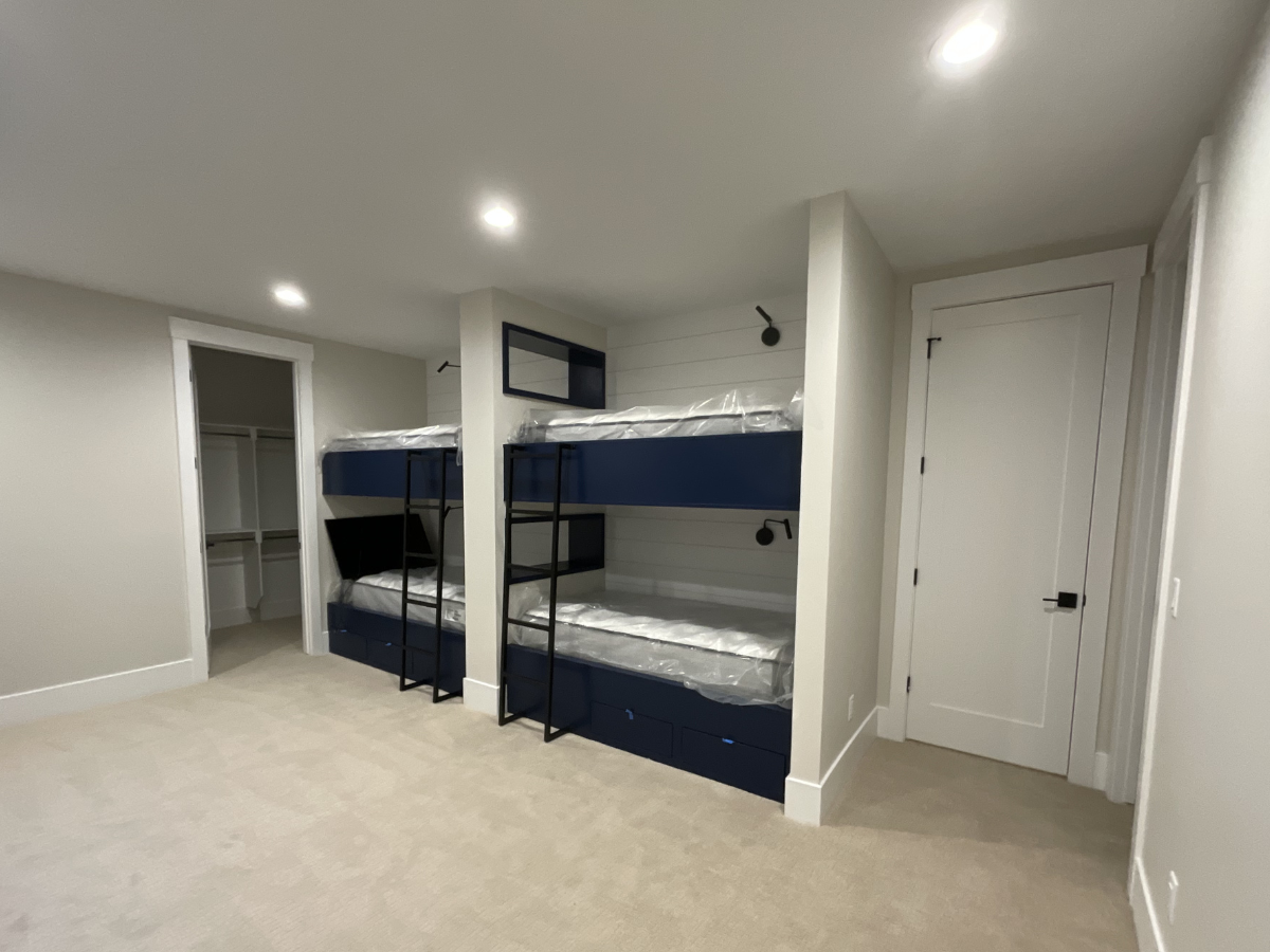 Modern bedroom interior with neutral wall colors, custom built-in bunk beds, recessed lighting, and professionally finished interior painting in contemporary Colorado home.