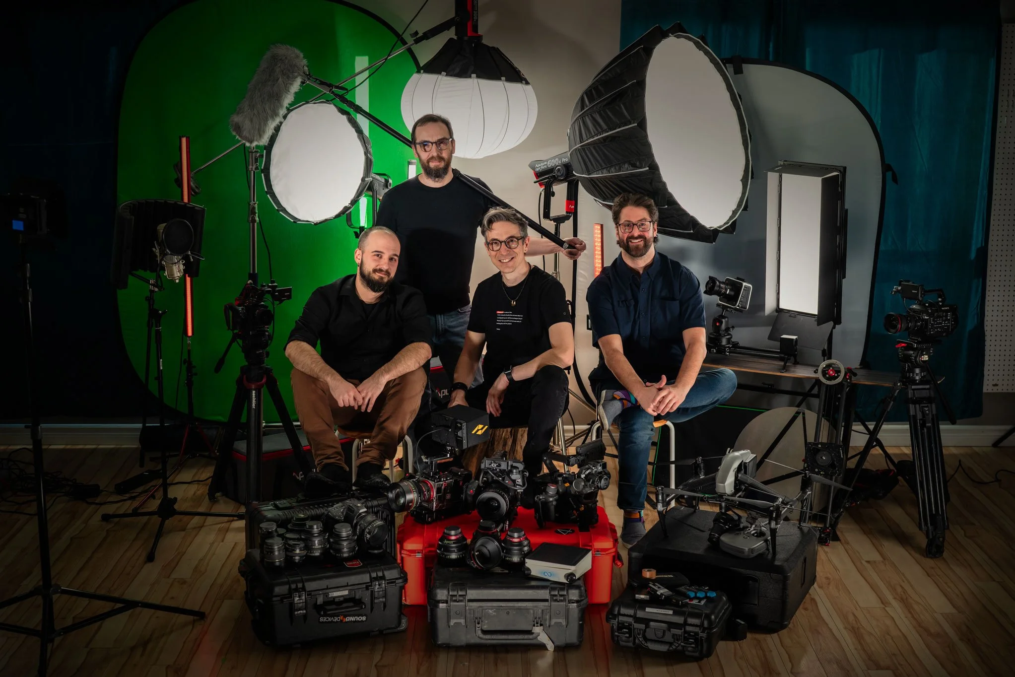 Adama Production dans un studio de production vidéo, entouré d'équipements professionnels tels que caméras, lumières, et microphones, avec un fond vert et un fond blanc.