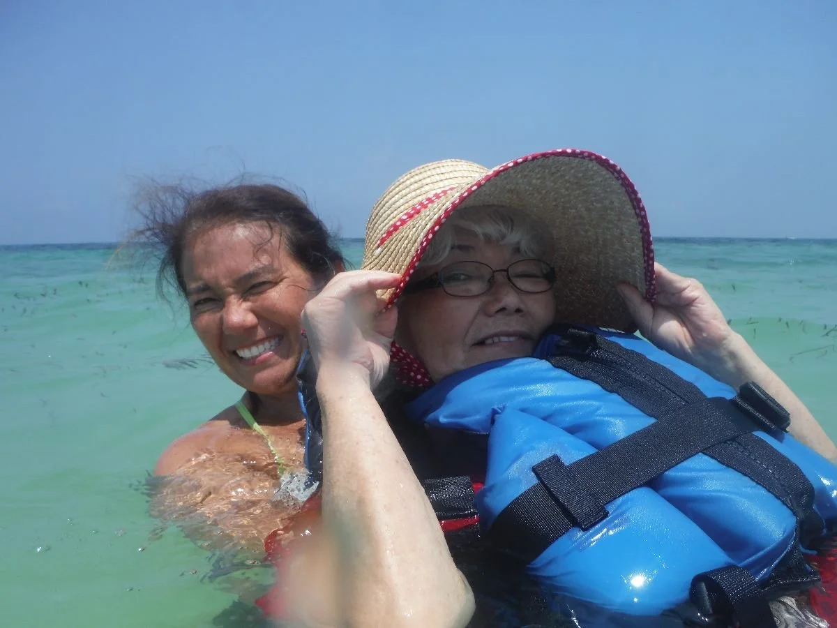 Onna water photo: Mother and daughter laughing together in ocean water