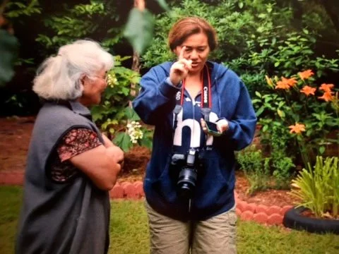 Camera in backyard: Daughter showing mother photography on camera in garden