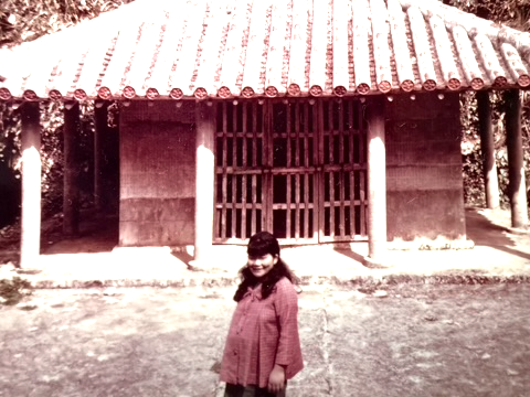 Mom pregnant in Itoman: Pregnant woman standing in front of traditional Okinawan structure