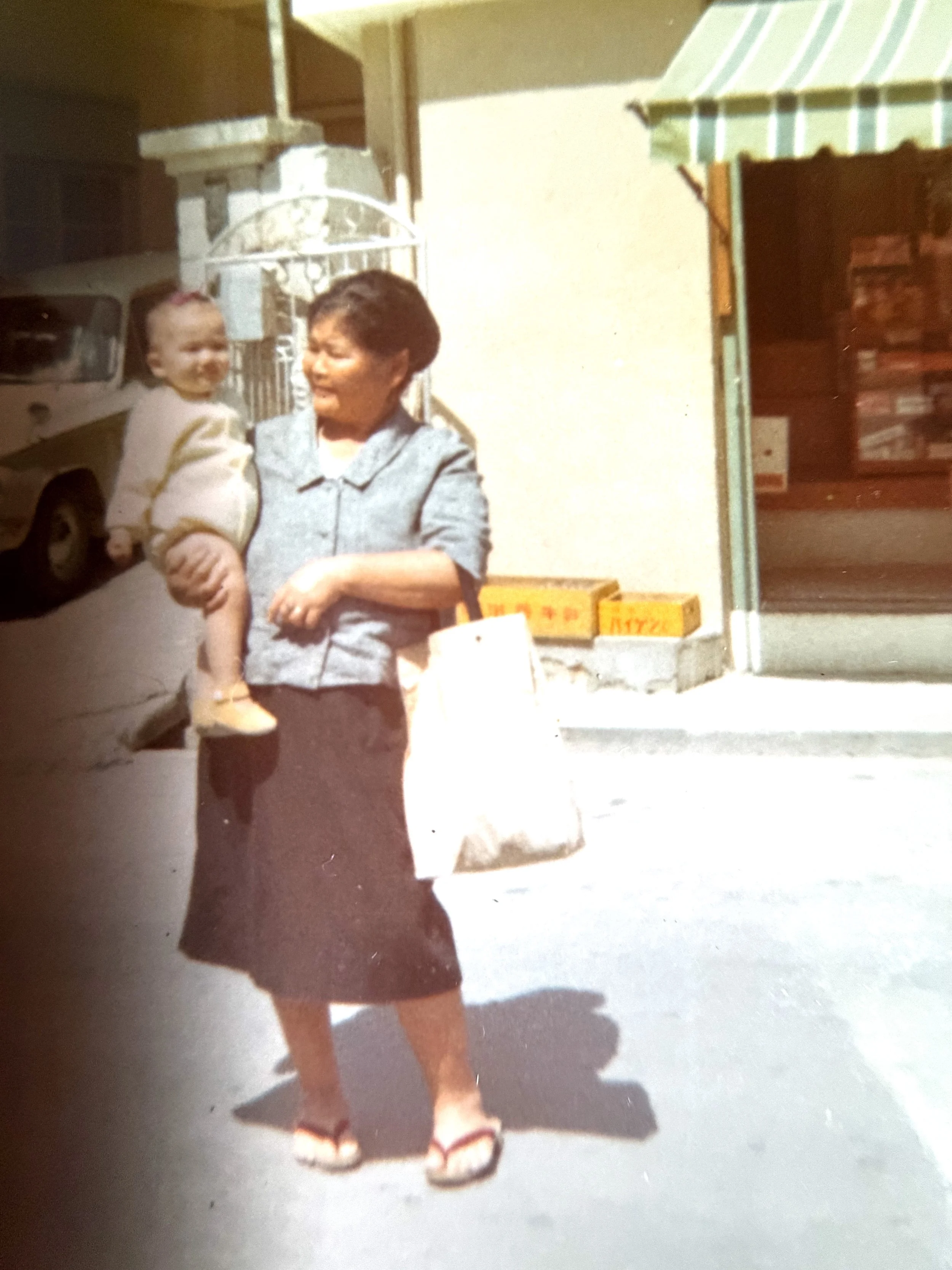 Grandmother: Grandmother carrying baby on a street