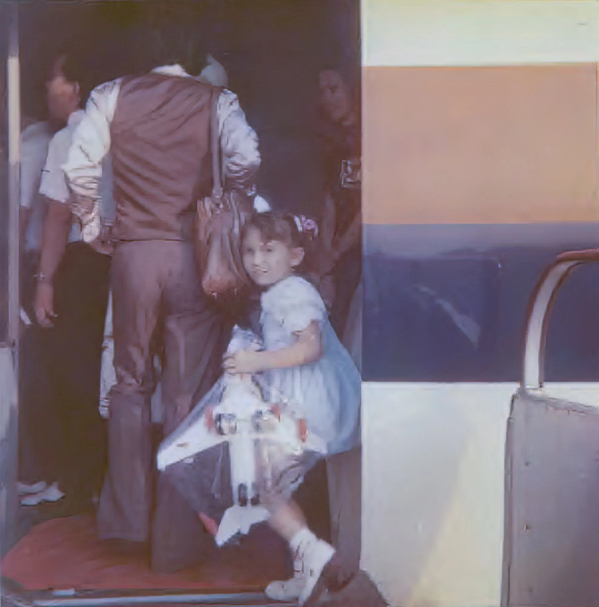 A little girl boarding an airplane holding a plastic toy plane