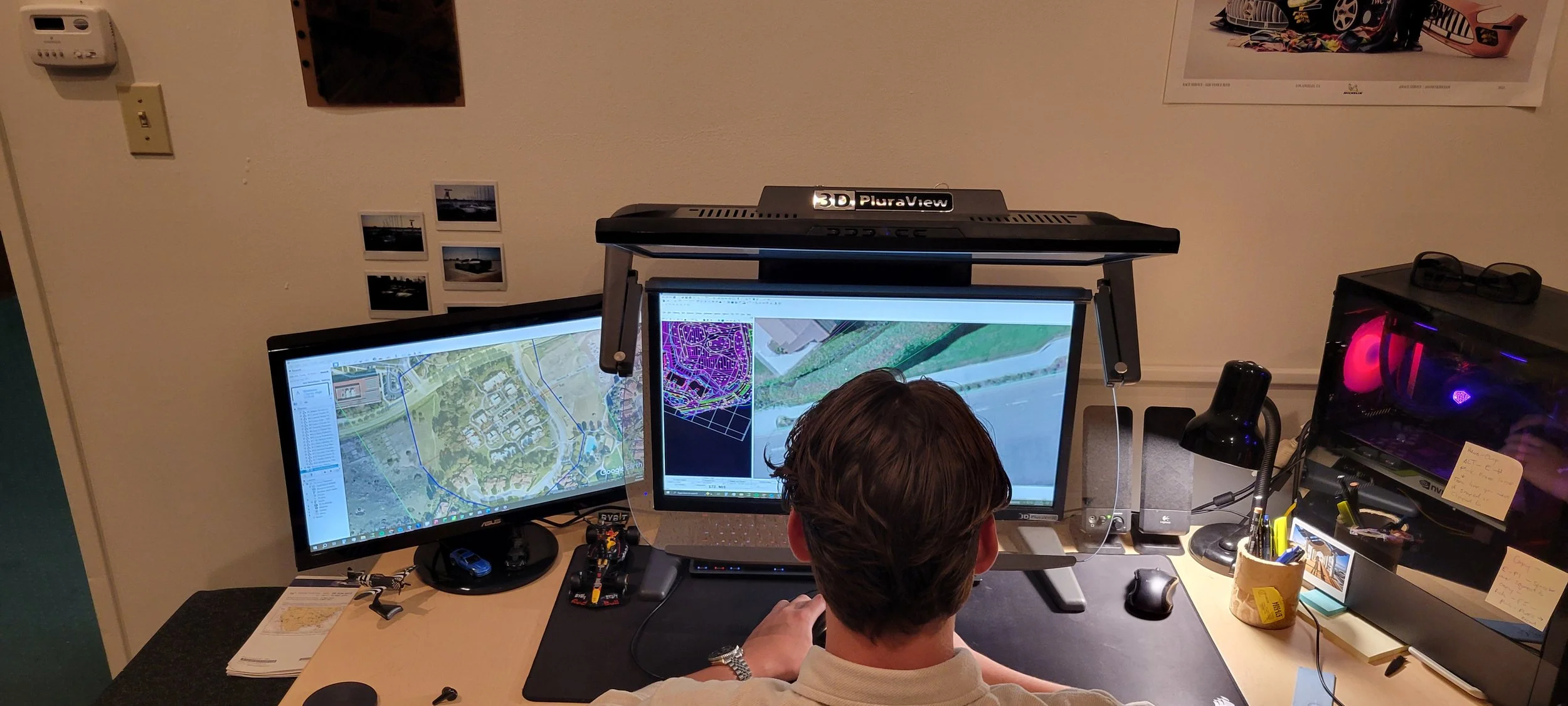An employee working at a desk with a PluraView 3D monitor displaying maps and geographic data. Mapping, topographic maps, GIS, LiDAR, aerial mapping, SoCal, Southern California, aerial mapping, aerial imagery