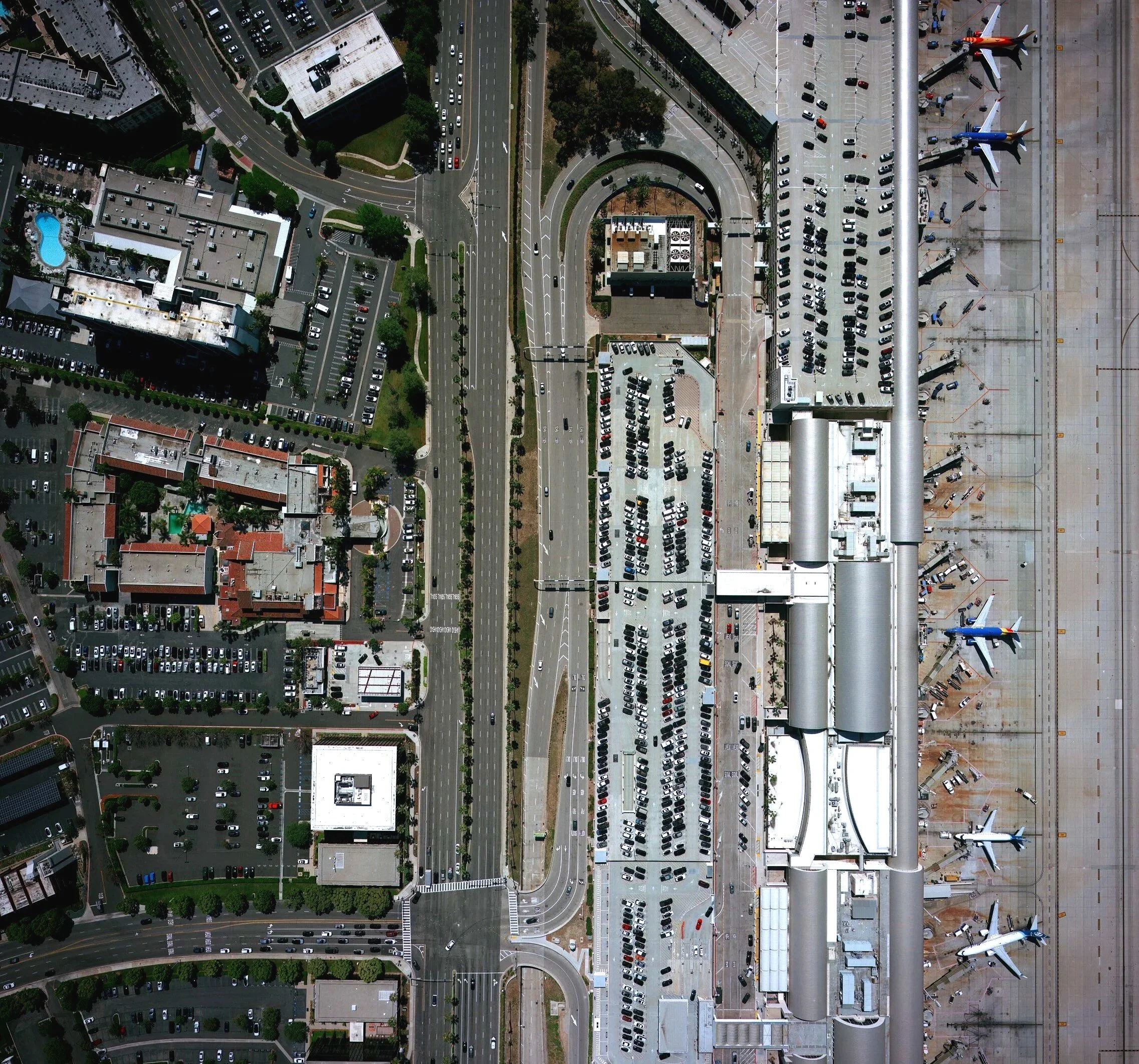 An aerial imagery view of an urban area, Irvine, with roads, parking lots, buildings, and airplanes at John Wayne airport's terminal. Mapping, topographic maps, GIS, LiDAR, aerial mapping, SoCal, Southern California, aerial mapping, aerial imagery
