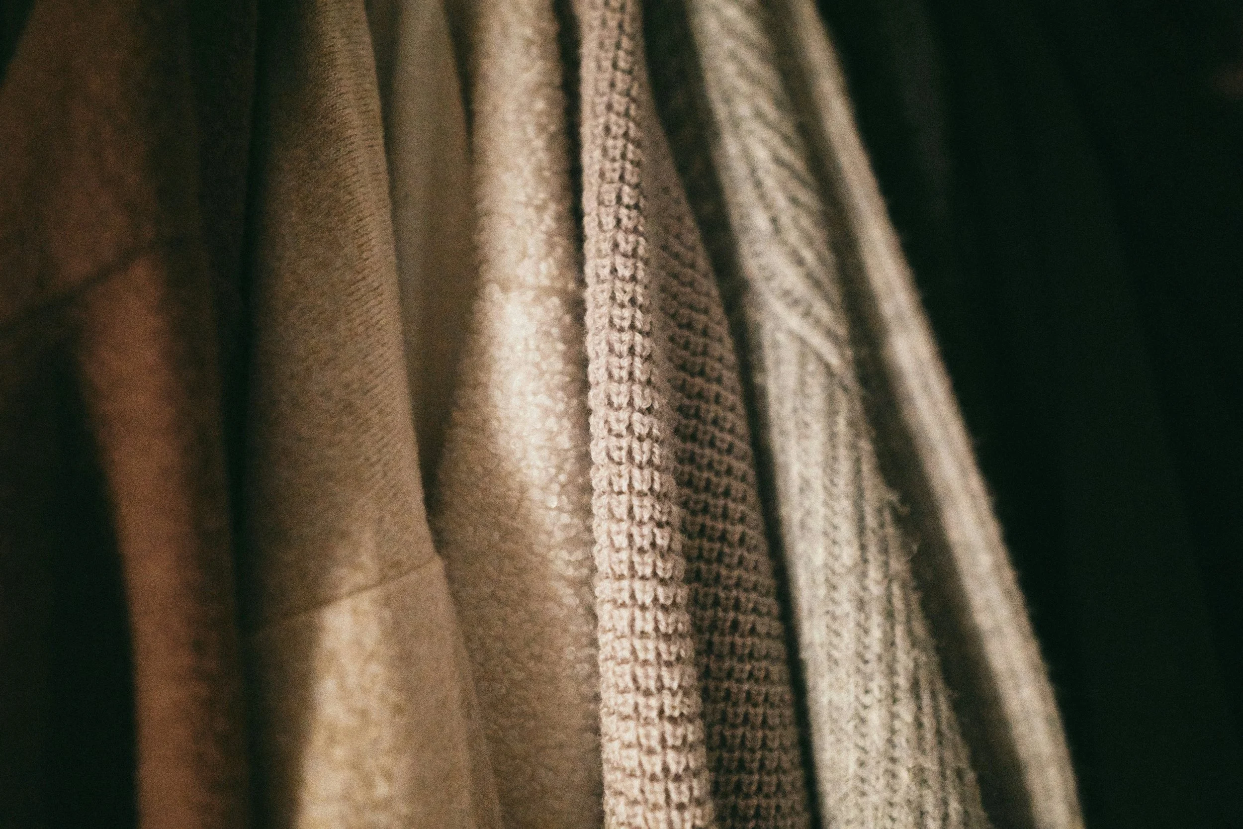 Close-up of hanging beige and brown clothing fabrics.