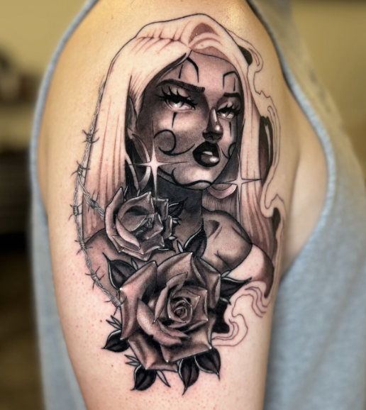 Black and gray portrait of a woman with long hair, surrounded by roses and thorns tattooed on a person's upper arm.