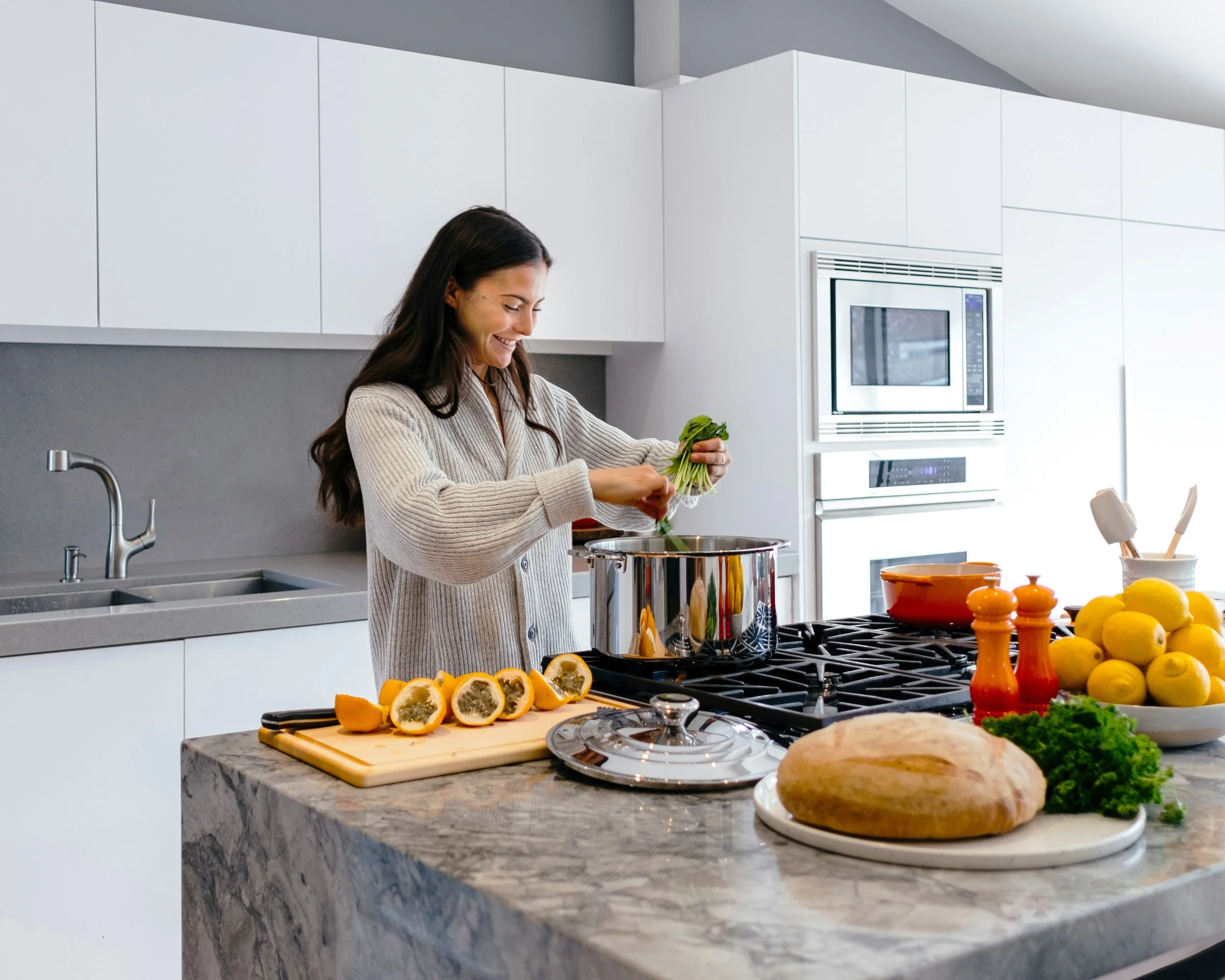 Happy woman cooking in her modern home, smiling. Arcadia Women's Wellness Modern Health Practice - Phoenix Arizona