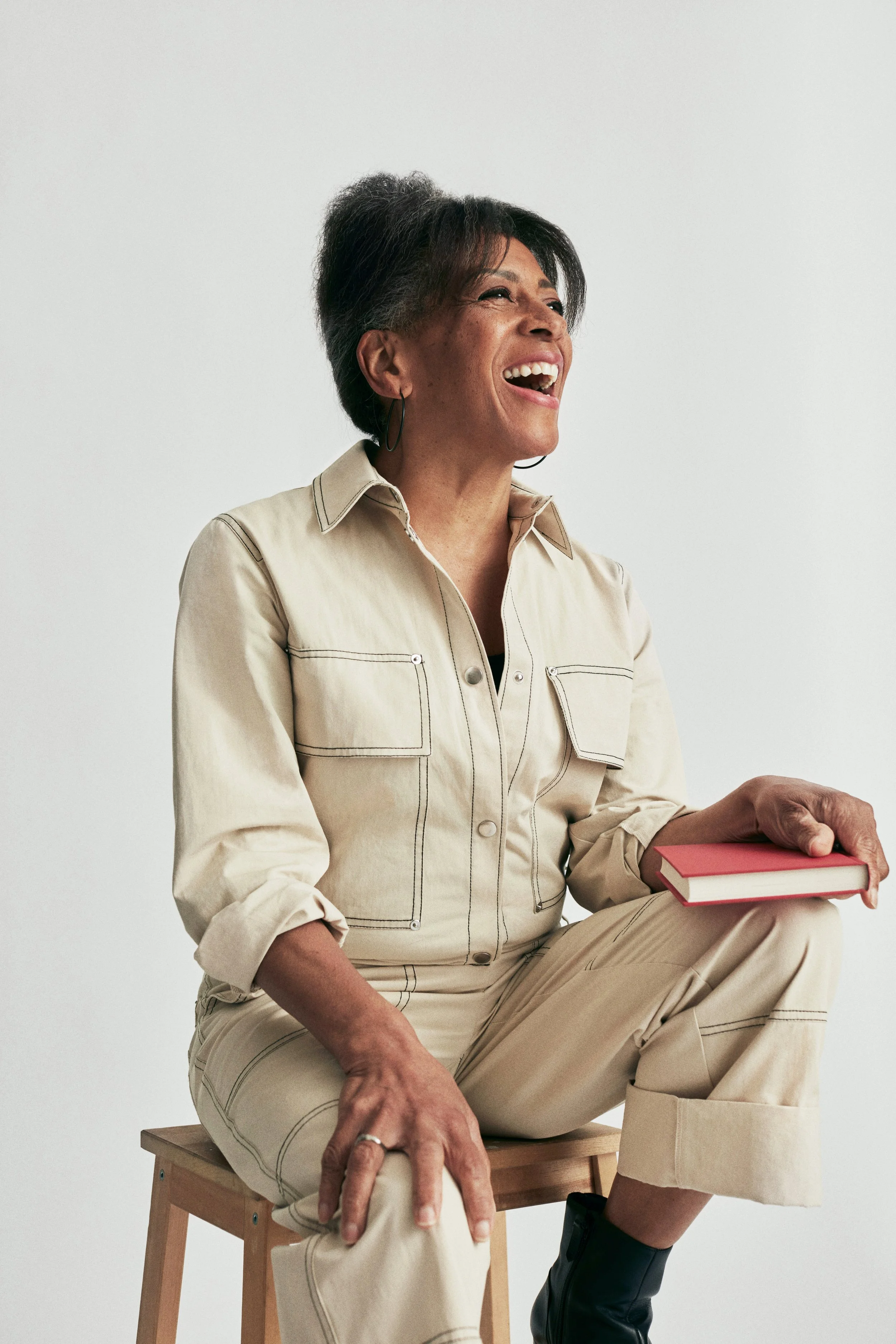 Woman laughing into the distance while wearing a tan outfit and sitting. Arcadia Women's Wellness Health Conditions We Treat - Scottsdale Arizona