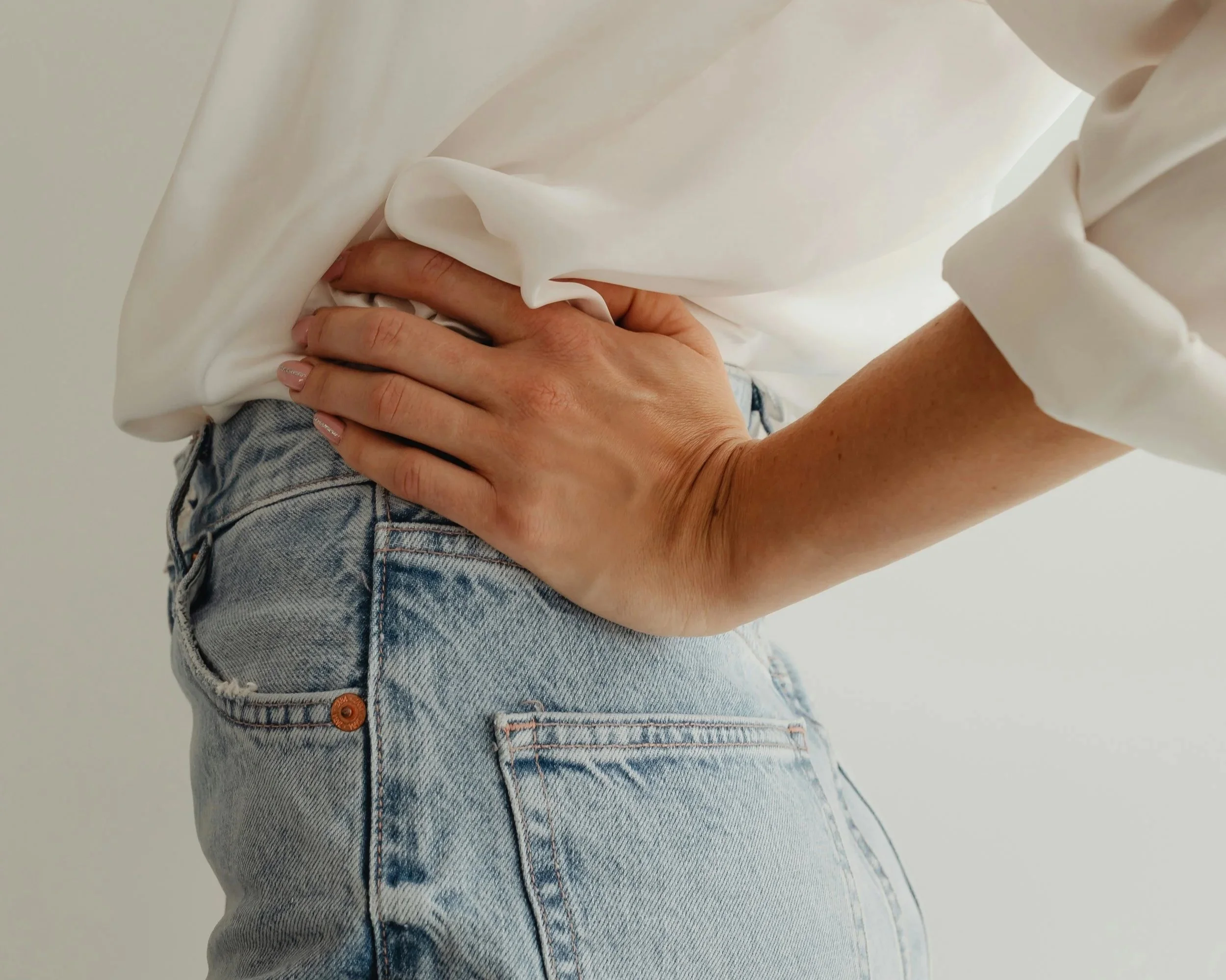 Woman holding her stomach area in pain from Endometriosis.