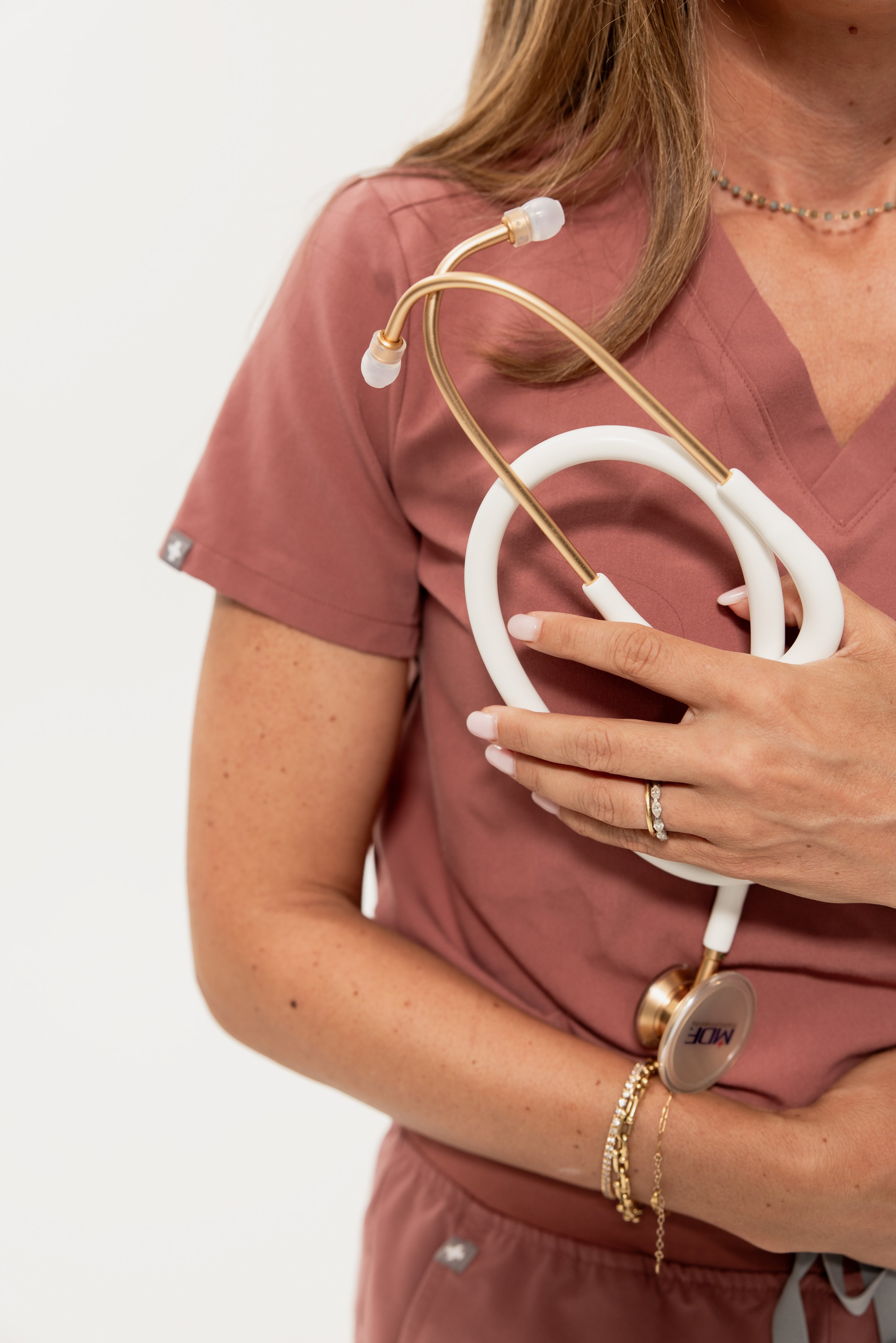 Woman wearing mauve scrubs and holding a stethoscope. Arcadia Women’s Wellness Menopause and Hormone Therapy - Phoenix Arizona