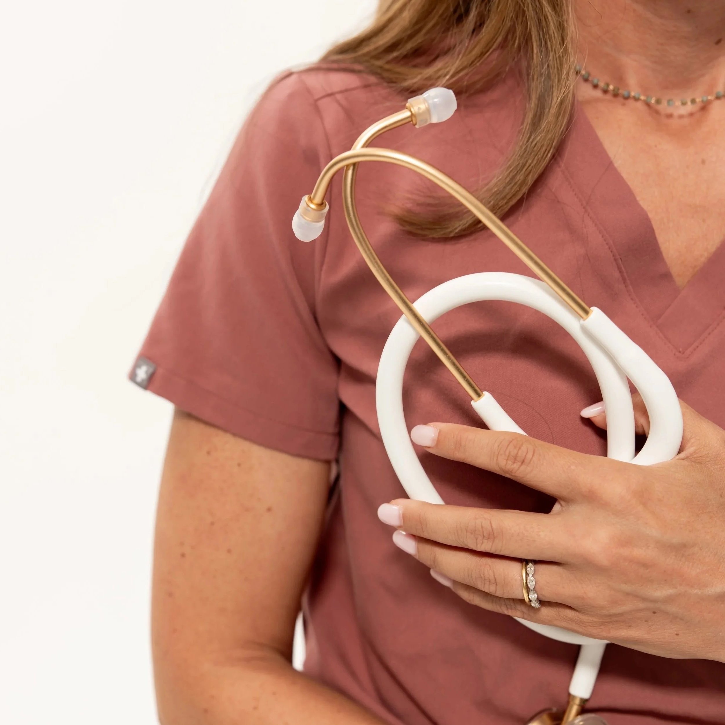 Woman wearing mauve scrubs while holding a stethoscope. Arcadia Women's Wellness Modern Health Practice - Scottsdale Arizona