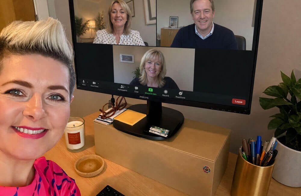 Ciara Crossan smiling beside a desktop monitor showing a video call with three hotel senior management participants during her six-month programme.