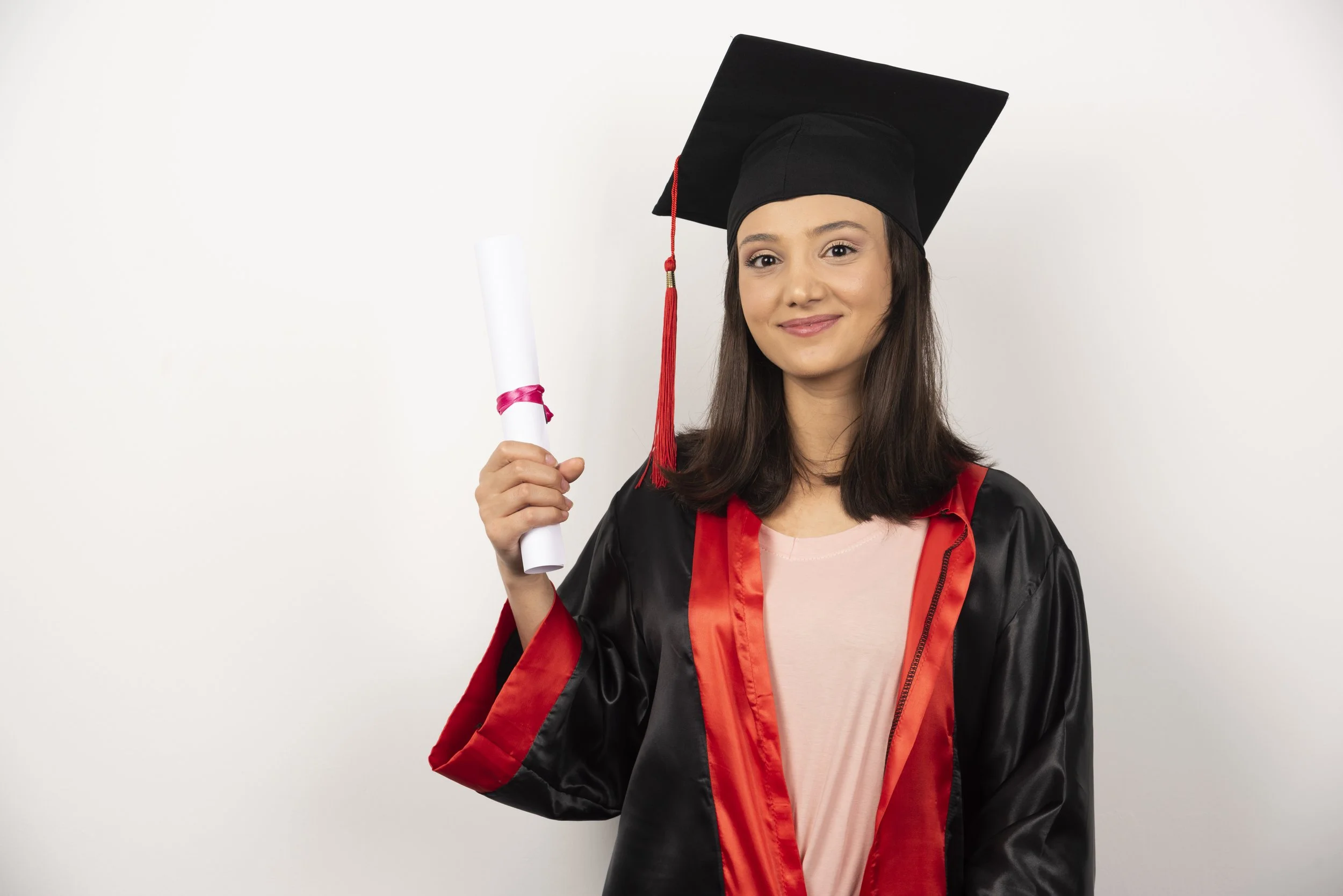 Young woman in a graduation gown and cap holding a diploma.
