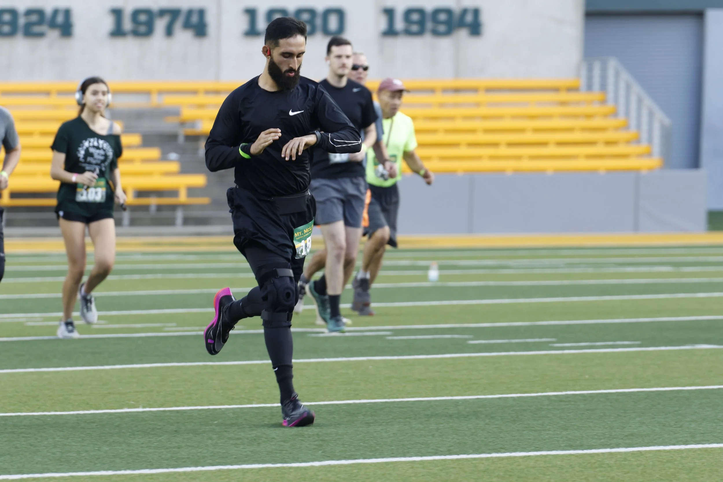 Runners crossing the field at McLane Stadium during a past Mt. McLane race in 2024.