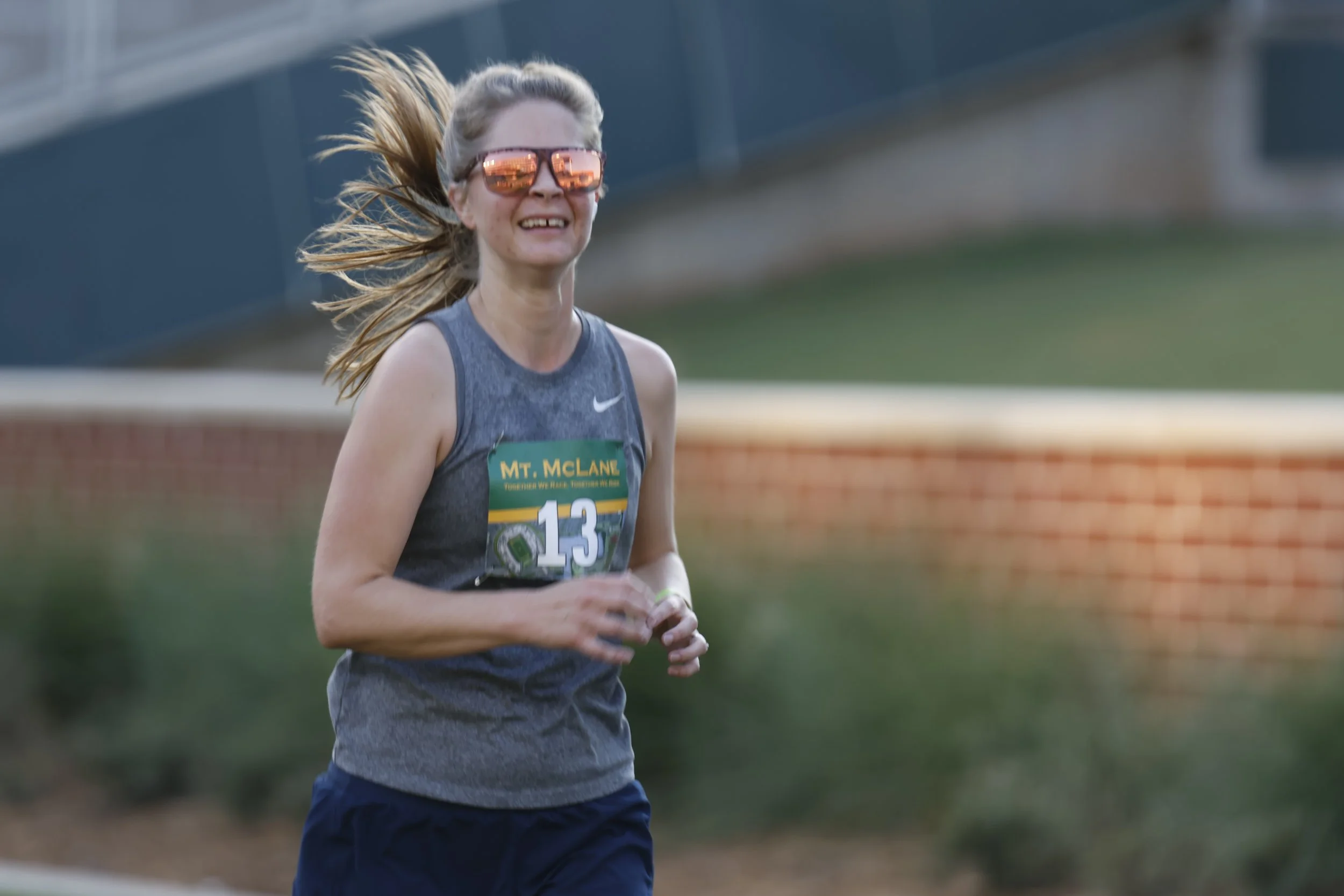 A smiling runner wearing a Mt. McLane race bib at the 2024 event.