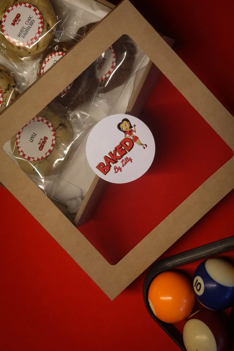 Boîte à biscuits contenant des cookies emballés et une boîte de boules de billard