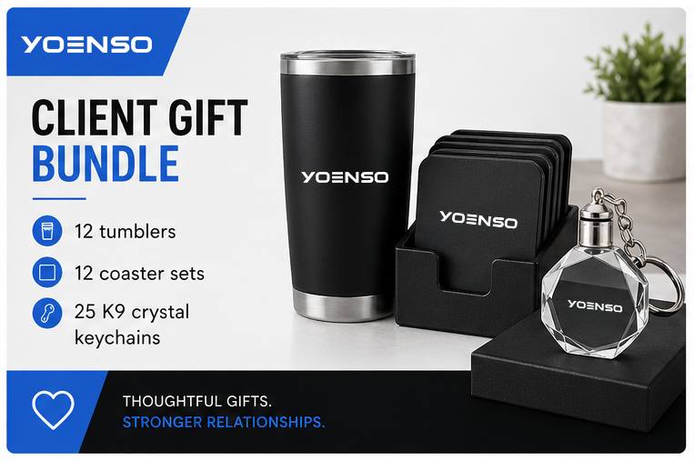 Yoenso client gift bundle includes 12 tumblers, 12 coaster sets, 25 K9 crystal keychains, a black travel tumbler, a set of black coasters, and a crystal keychain, displayed on a white surface with a small potted plant in the background.