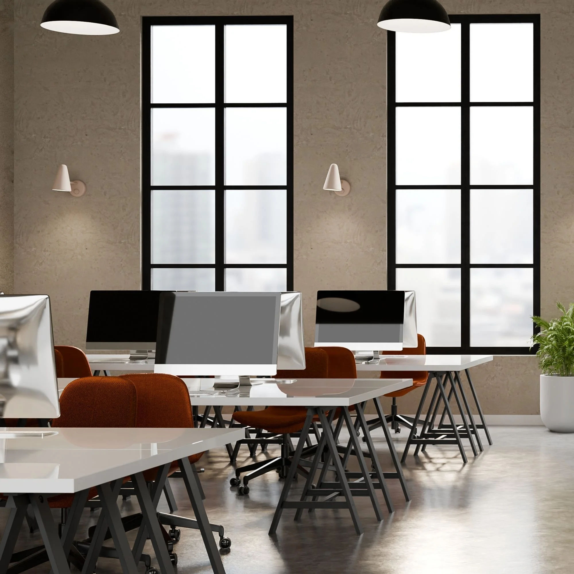 A modern office space with multiple white desks, red chairs, and computer monitors. Large windows with black frames allow natural light. Black pendant lamps hang from the ceiling, and wall-mounted cone-shaped white lamps are on the beige textured wall.
