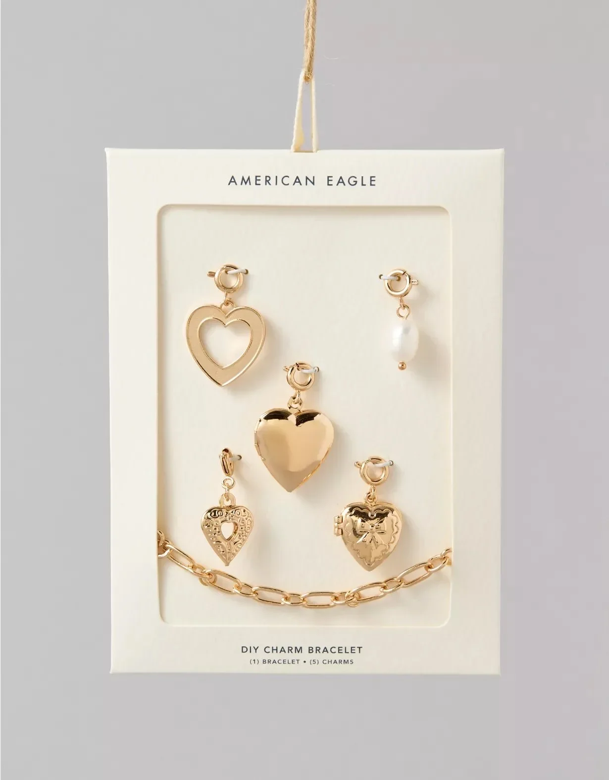 Set of gold-toned charms and earrings on a white display card labeled "American Eagle" and "DIY Charm Bracelet" with one chain bracelet and five charms.