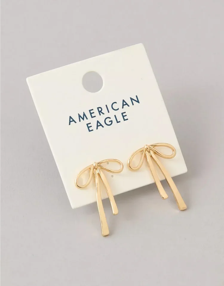 Gold bow-shaped earrings on white card labeled 'American Eagle'