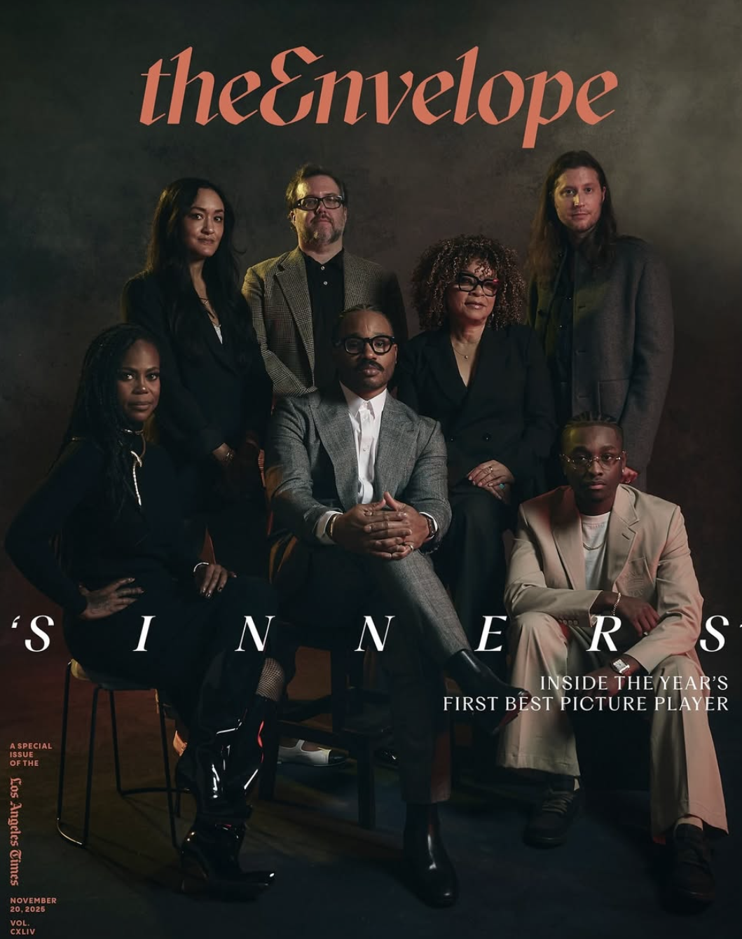 Cover of the magazine 'The Enveloper' featuring a diverse group of seven people dressed in formal attire, posing against a dark background, with text indicating a special issue about winners of the year's best picture player on November 20, 2025.