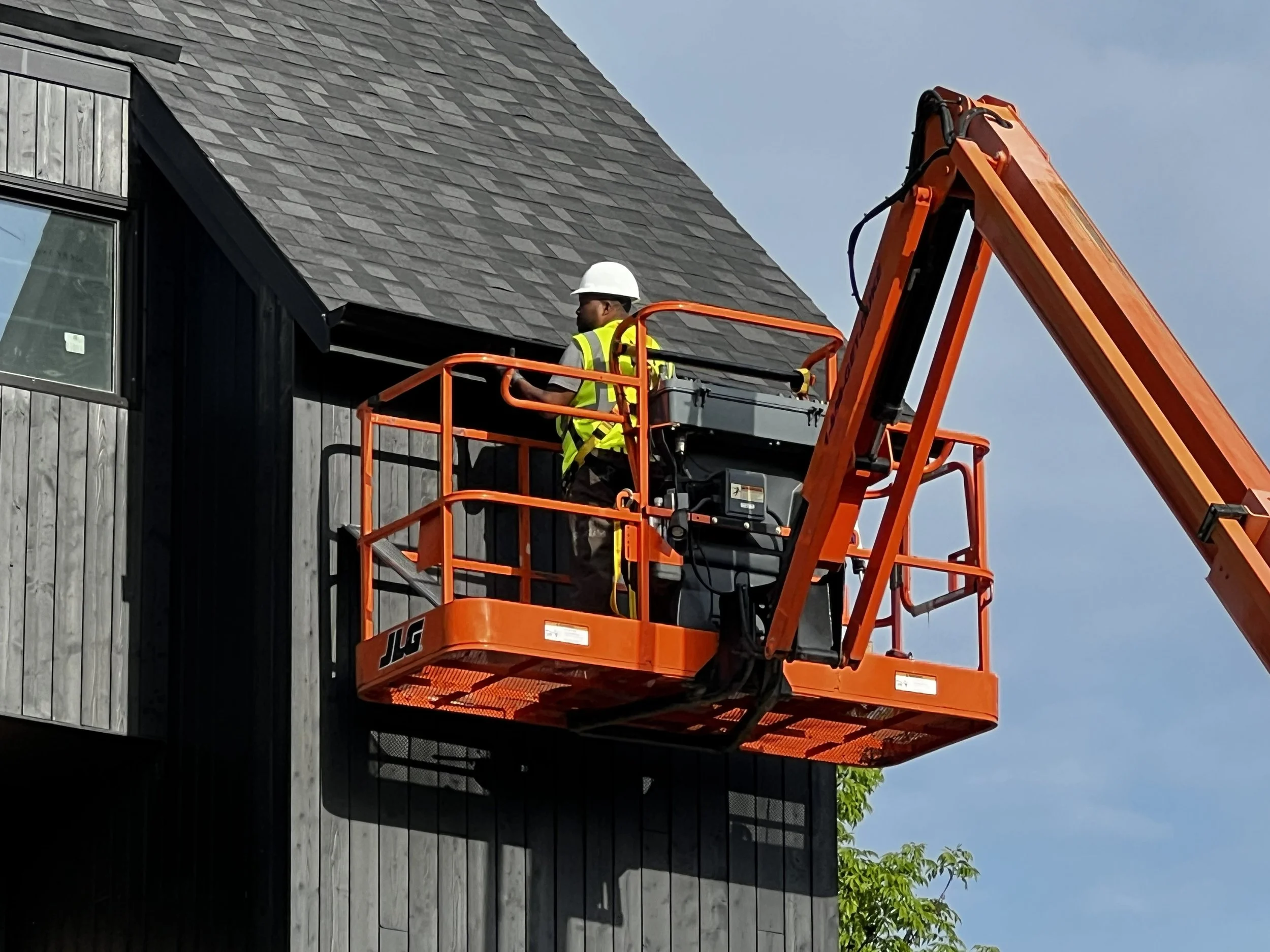 Owner, Tracie, on a job site installing gutters on a commercial property