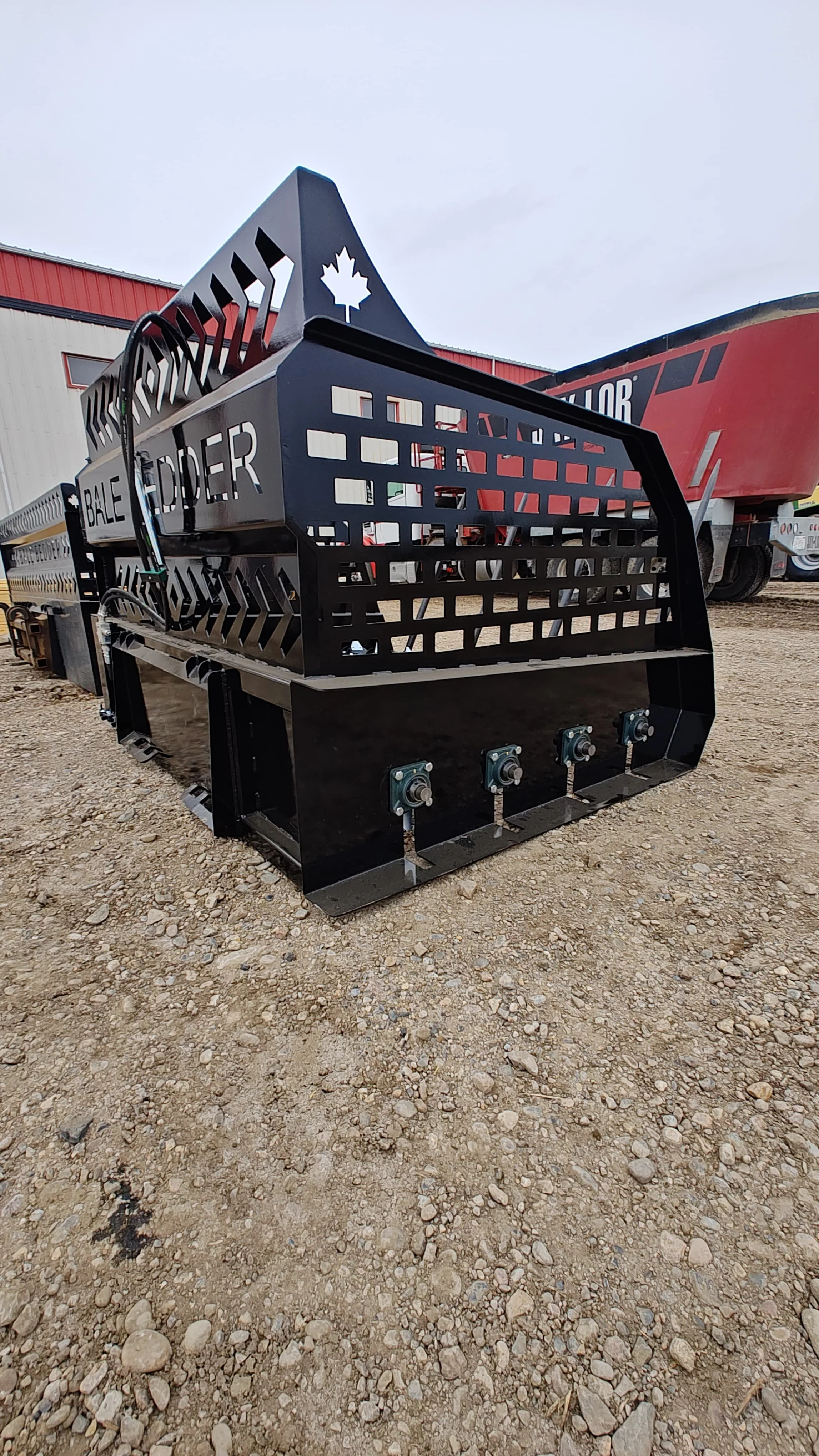 Black armored vehicle with the Canadian maple leaf and the words 'Bale Eder' on the side, parked on gravel ground in an outdoor lot.