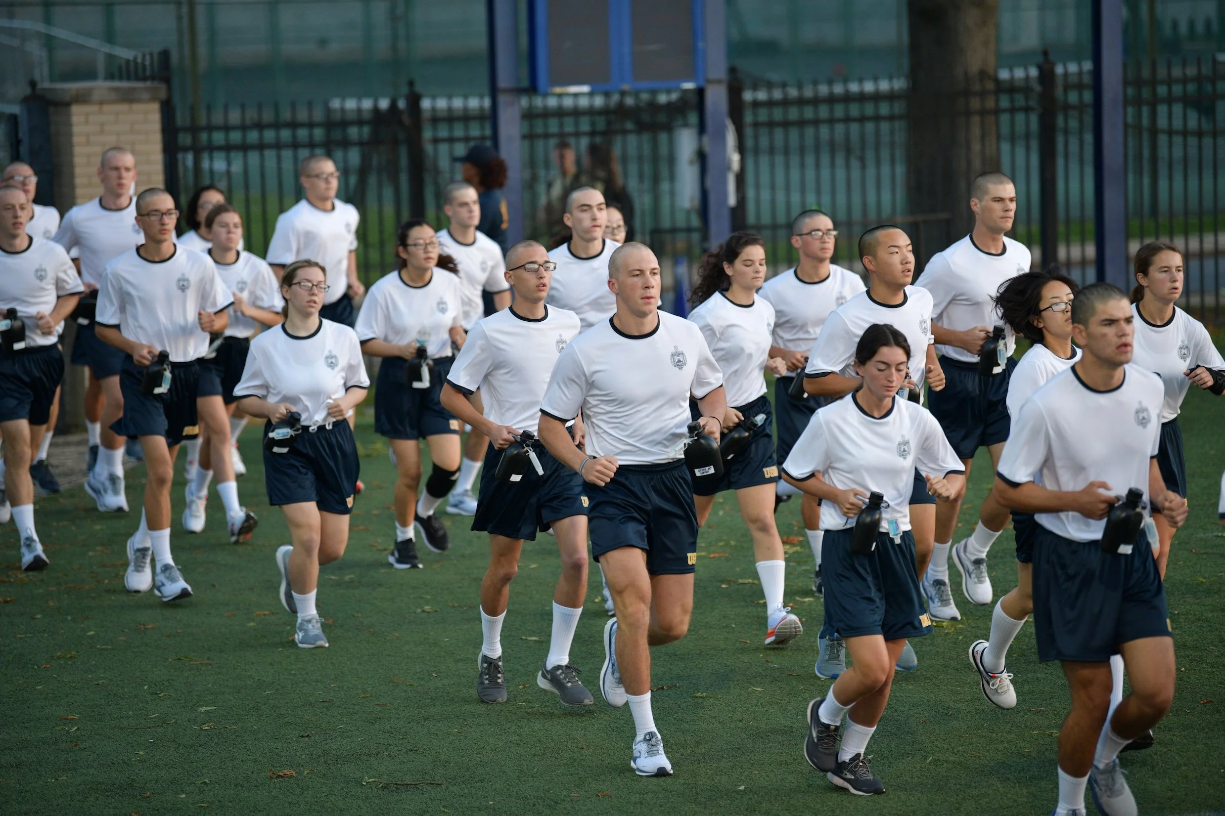 Plebs running onto a field in their workout apparel