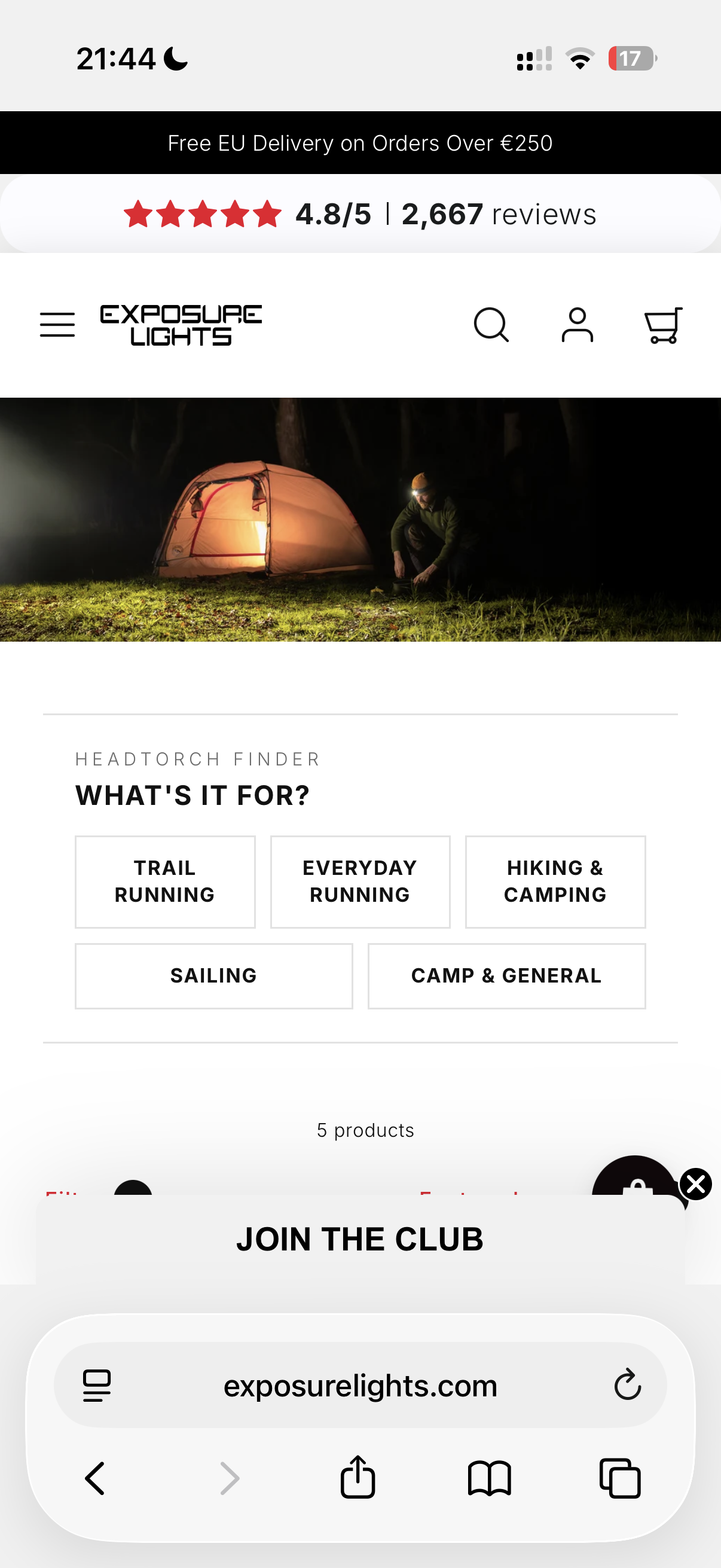 Nighttime scene of a person setting up camping gear outside a glowing tent in a forest.