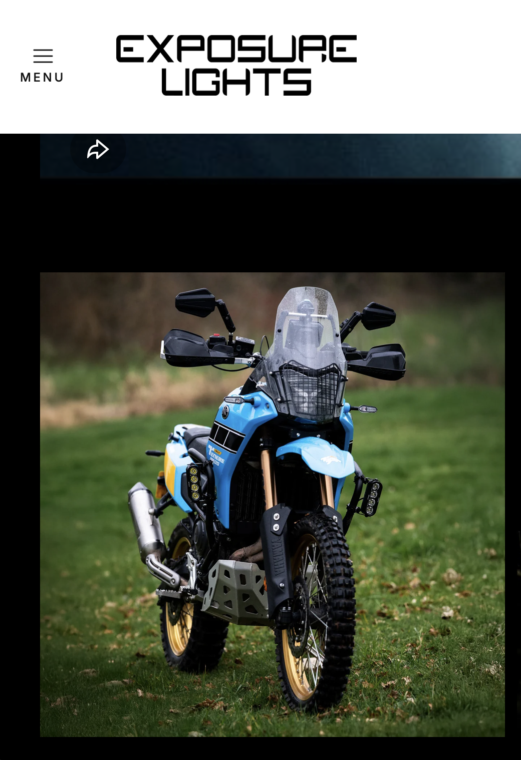 A blue off-road motorcycle with black and gold accents parked on grass.