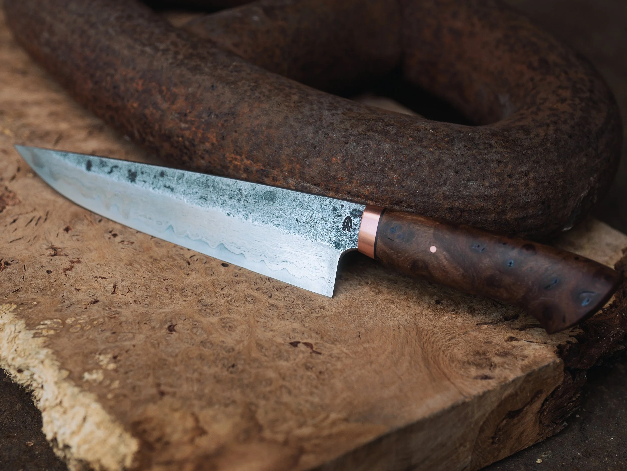 Close-up of a textured, rust-colored stone with a kitchen knife resting on its surface.
