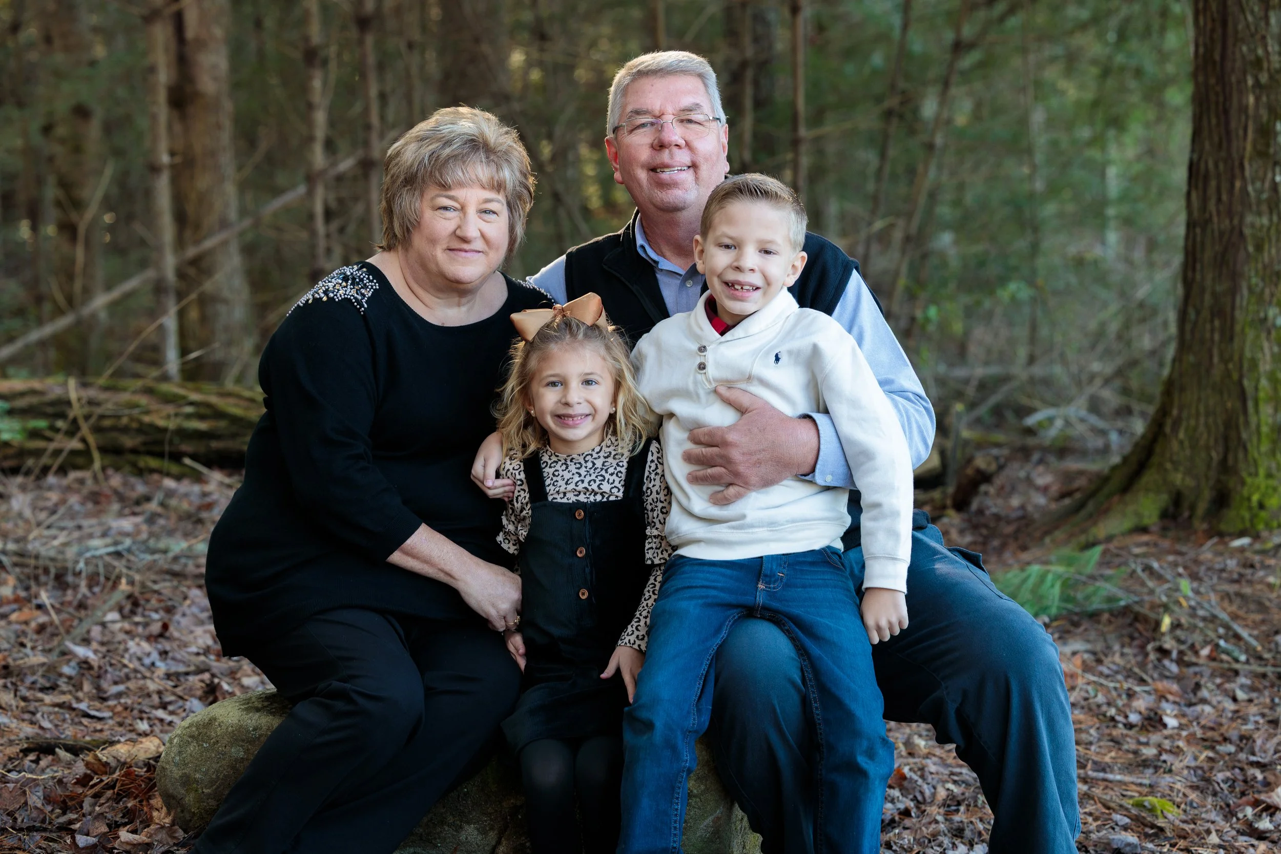 Two grandparents pose for a happy portrait with their grandchildren in the Great Smoky Mountains National Park.