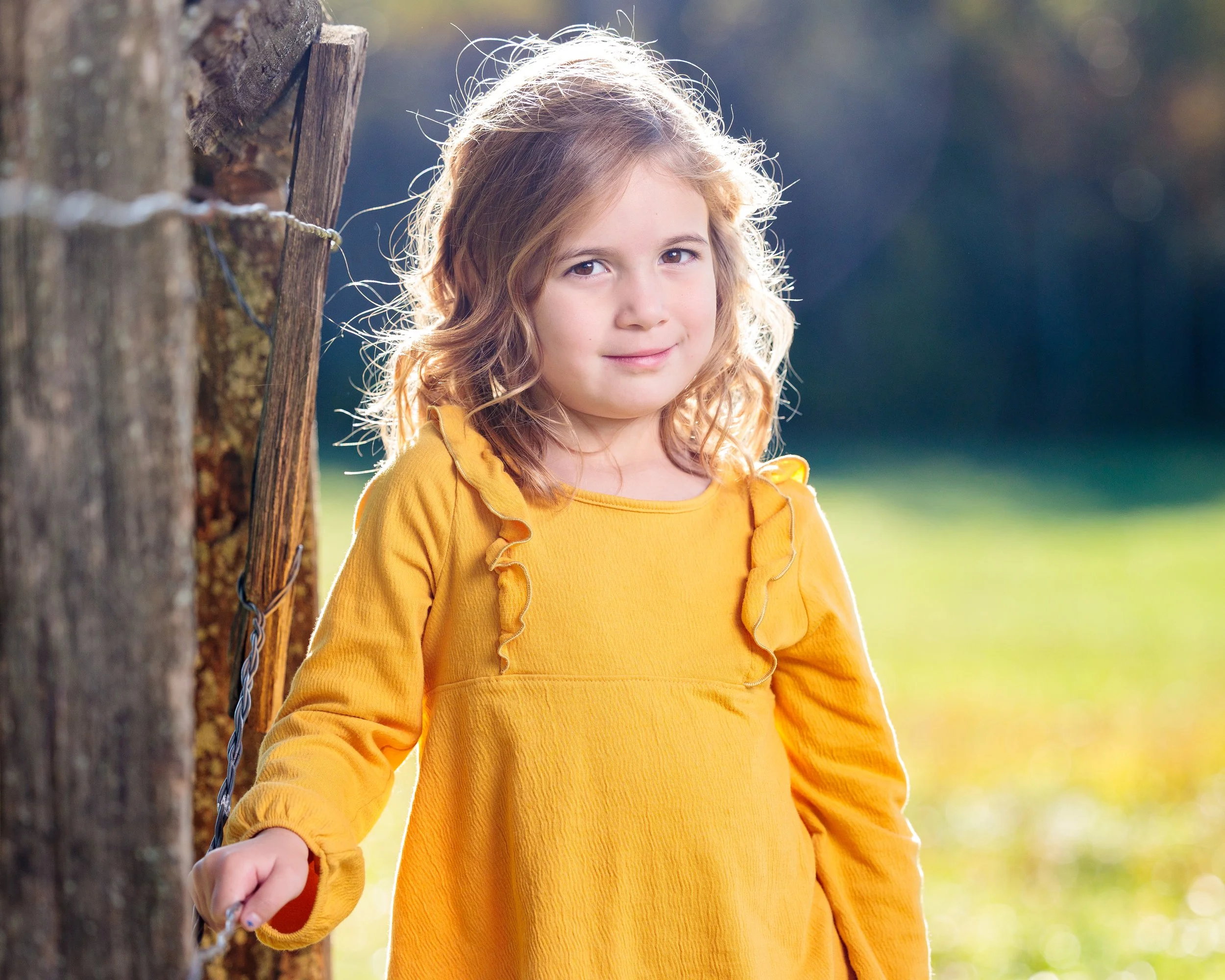 A young girl with long curly blonde posing for a portrait in the Great Smoky Mountains National Park
