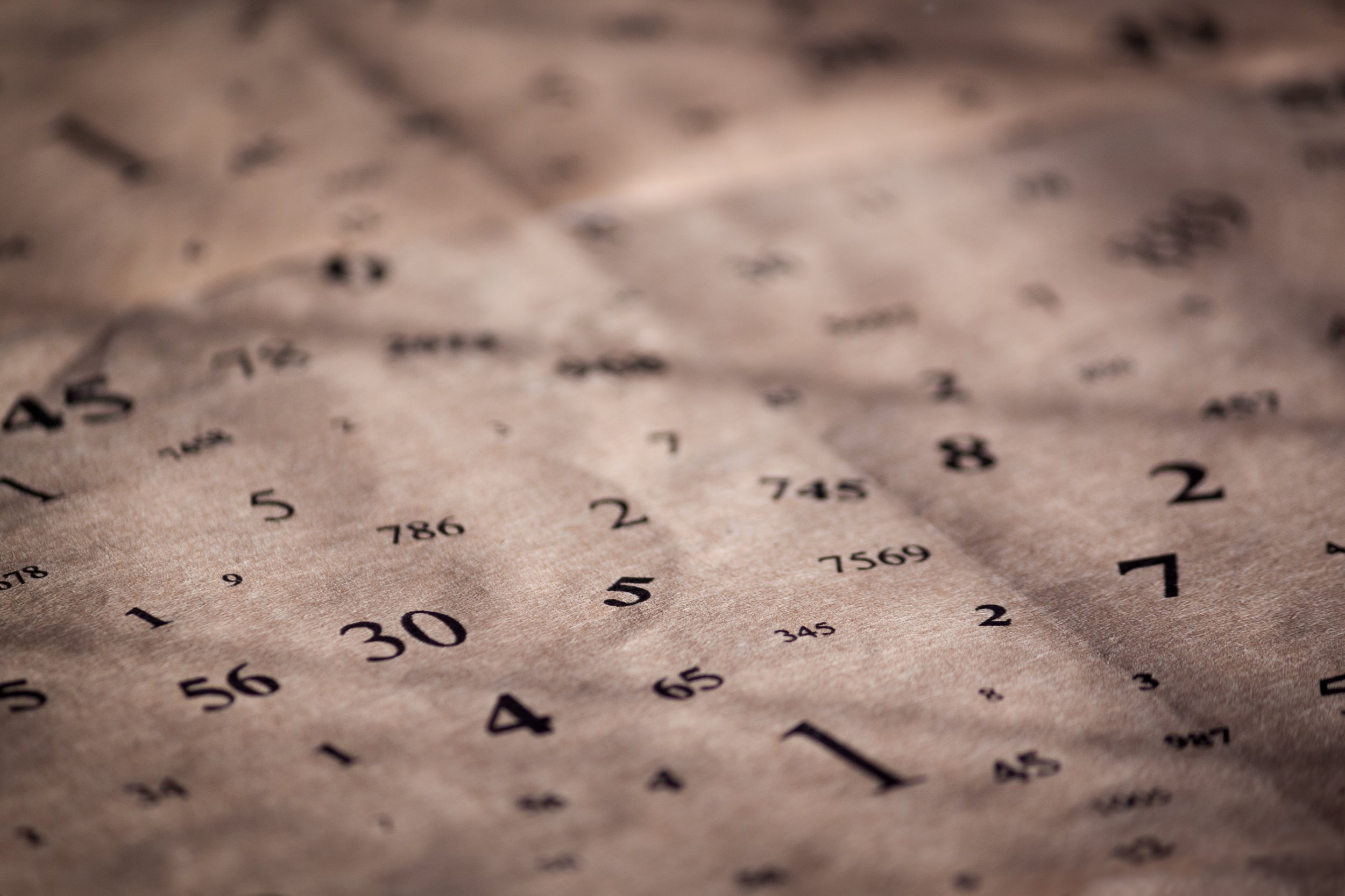Close-up photo of a sheet of paper with printed numbers and mathematical calculations, slightly crumpled.