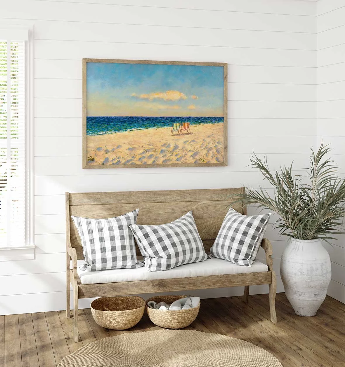 Sala de estar com parede de tábuas brancas, um quadro de praia, sofá de madeira com almofadas de xadrez em tons de cinza, vaso grande com planta, cestos de vime e tapete de fibra natural.